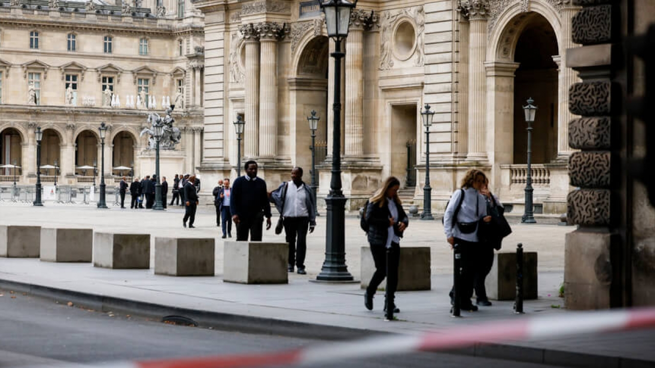 Staff leave the Louvre Museum as people are evacuated.