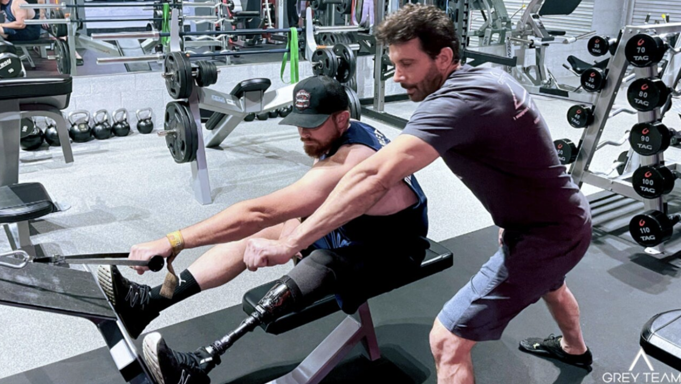 Grey Team founder Cary Reichbach helps veteran with a workout at the organization's Boca Raton Headquarters
