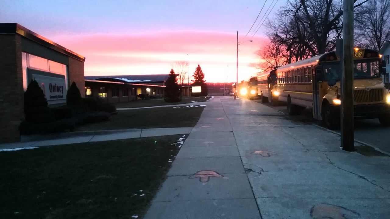 Quincy Community Schools building during bus drop off