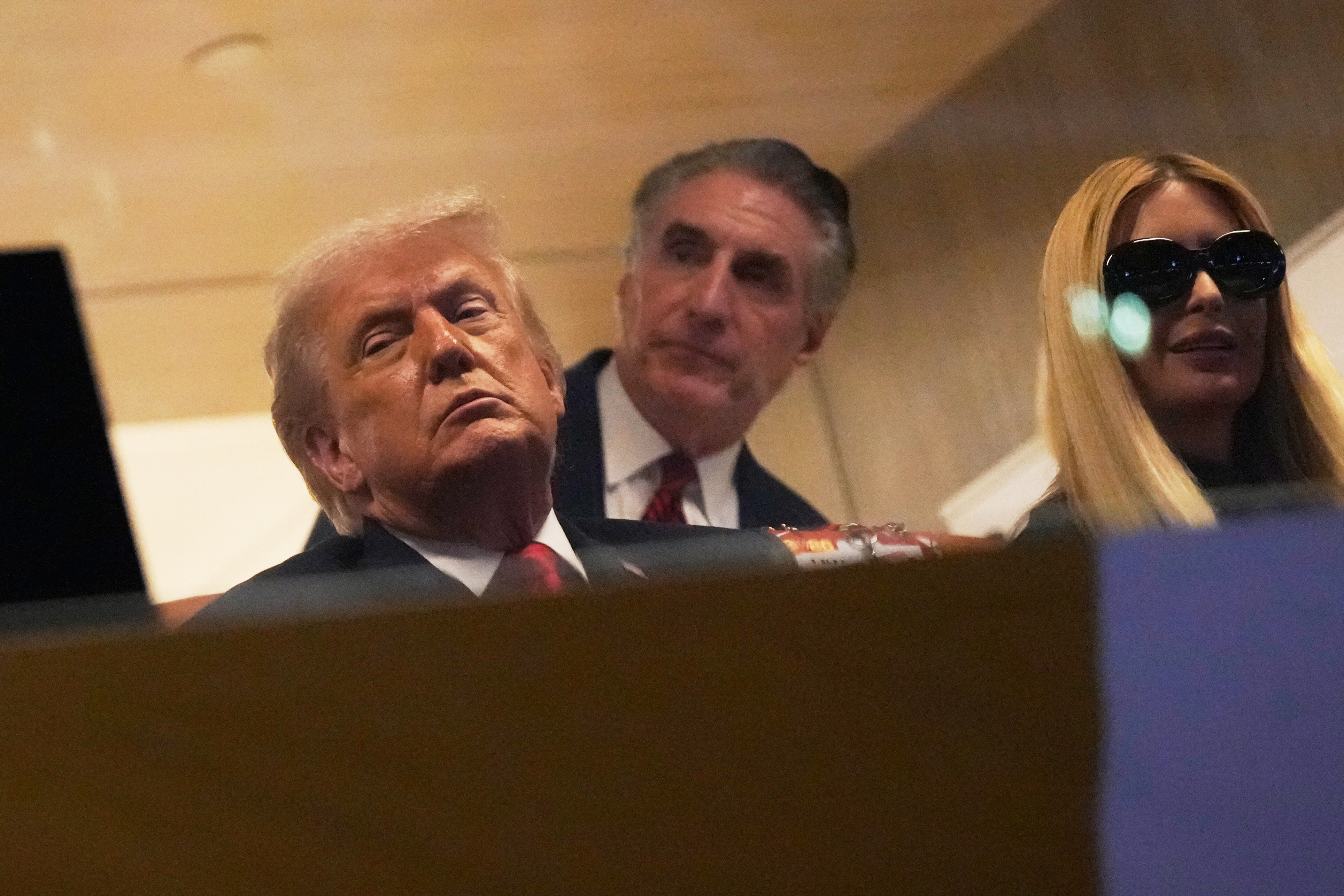 President Donald Trump watches first half of the College Football Playoff national championship game between Miami and Indiana, Monday, Jan. 19, 2026, in Miami Gardens, Fla., with Interior Secretary Doug Burgum and Ivanka Trump. 