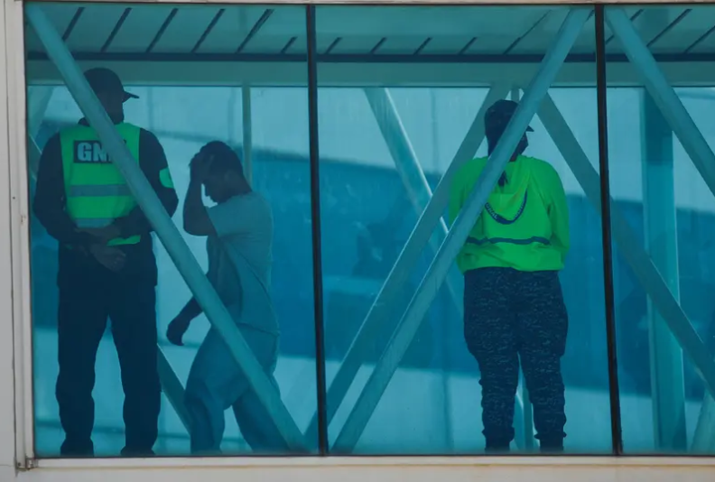 A man crosses a jet bridge as Venezuelan migrants arrive on a flight after being deported from the United States at the Simon Bolivar International Airport in Venezuela on March 30, 2025.
