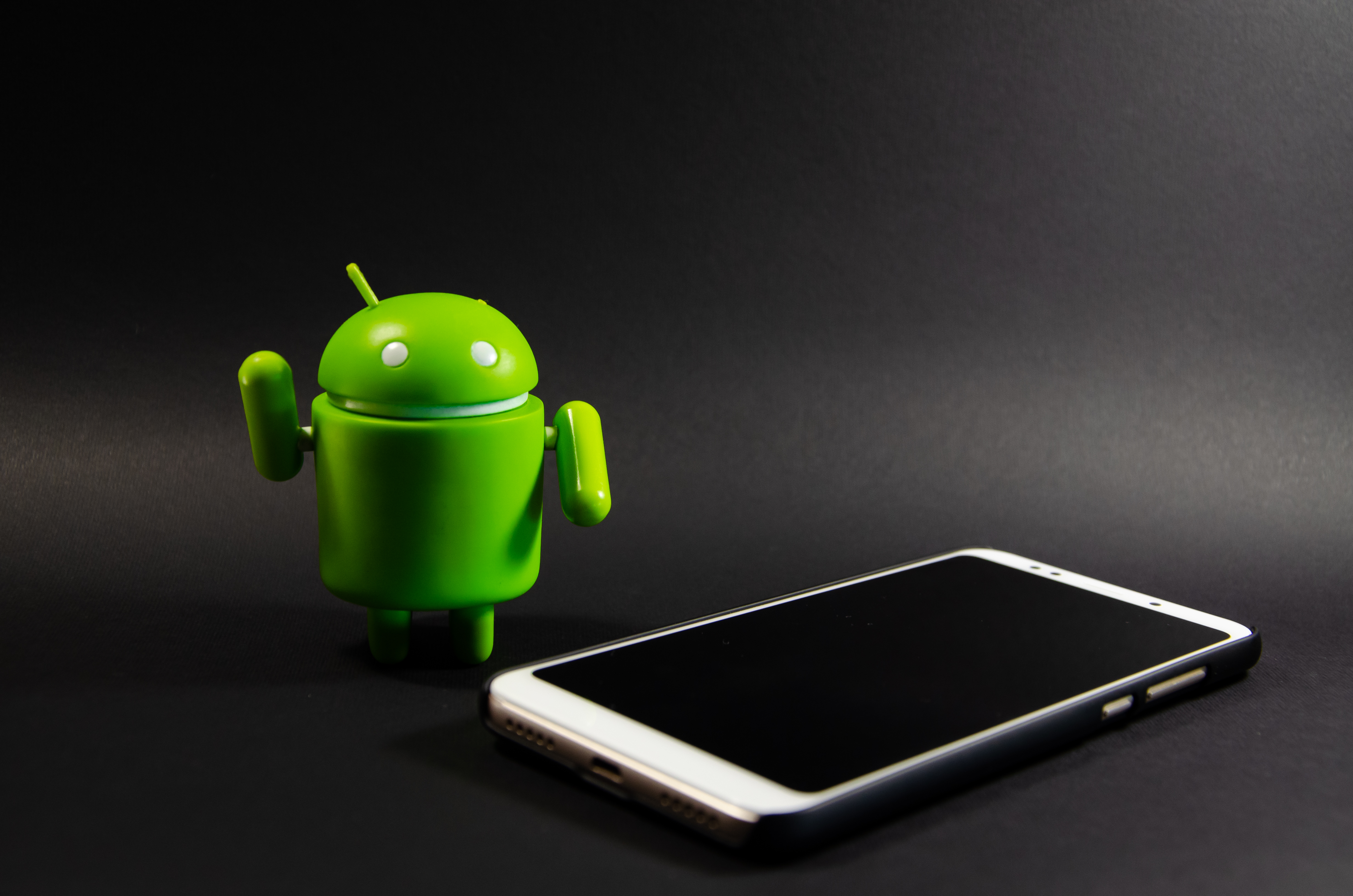 An Android phone next to an Android logo. 