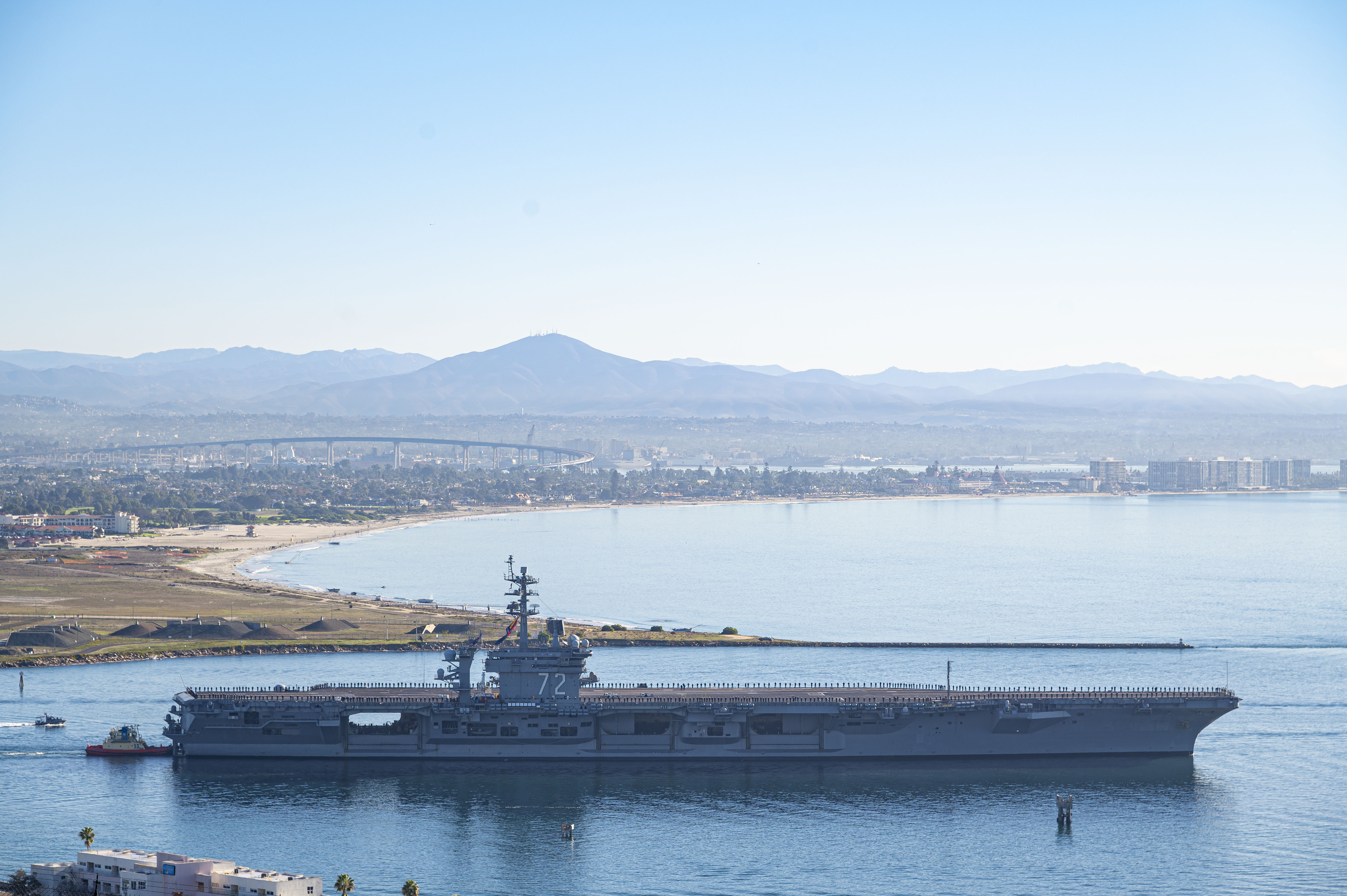 This aerial photo released by the U.S. Navy shows the aircraft carrier USS Abraham Lincoln (CVN-72) as it deploys from San Diego on Monday, Jan. 3, 2022.