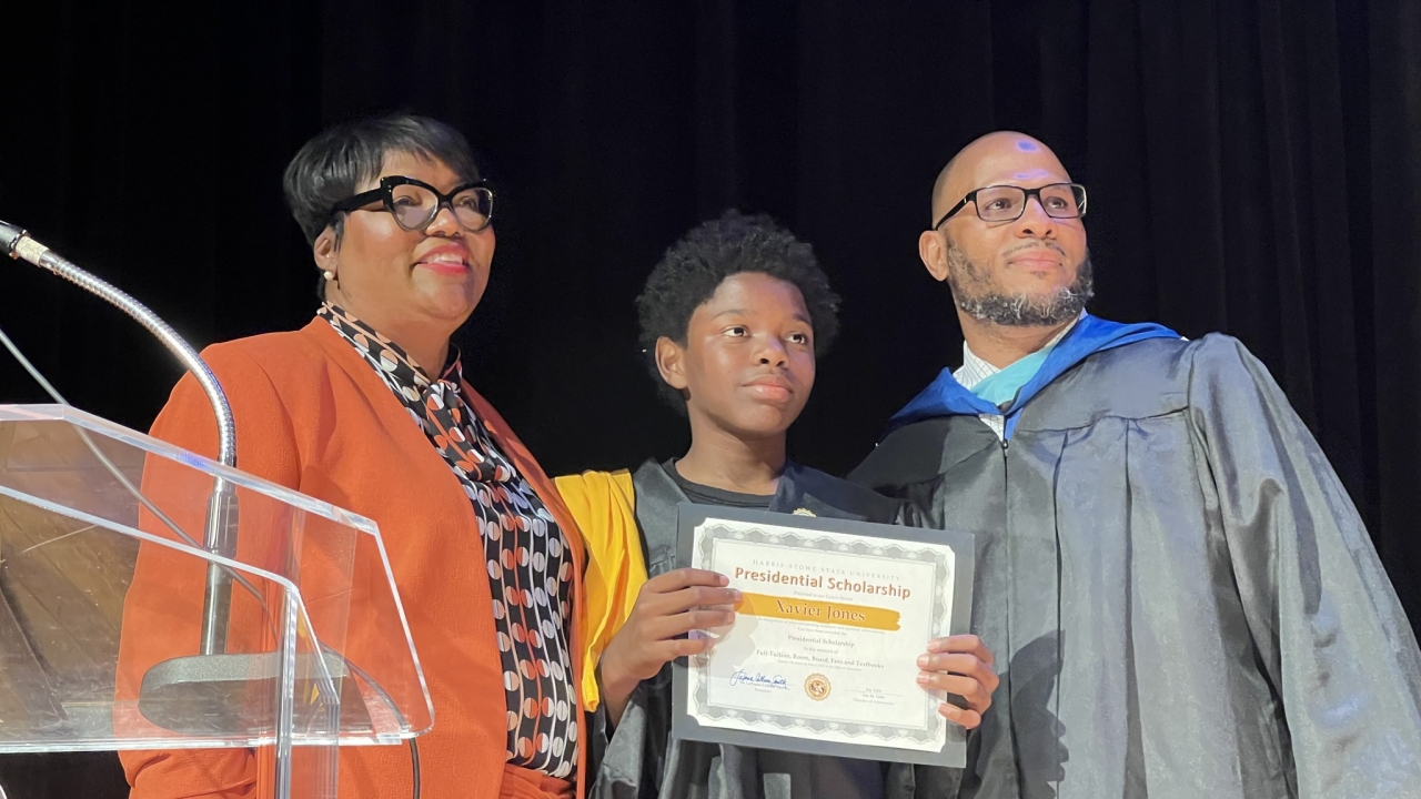 Xavier Jones holding a presidential scholarship certificate.