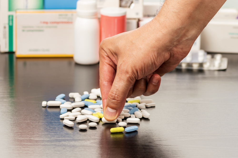 Cropped,Shot,Of,A,Man,Hand,Catching,A,Pill,From