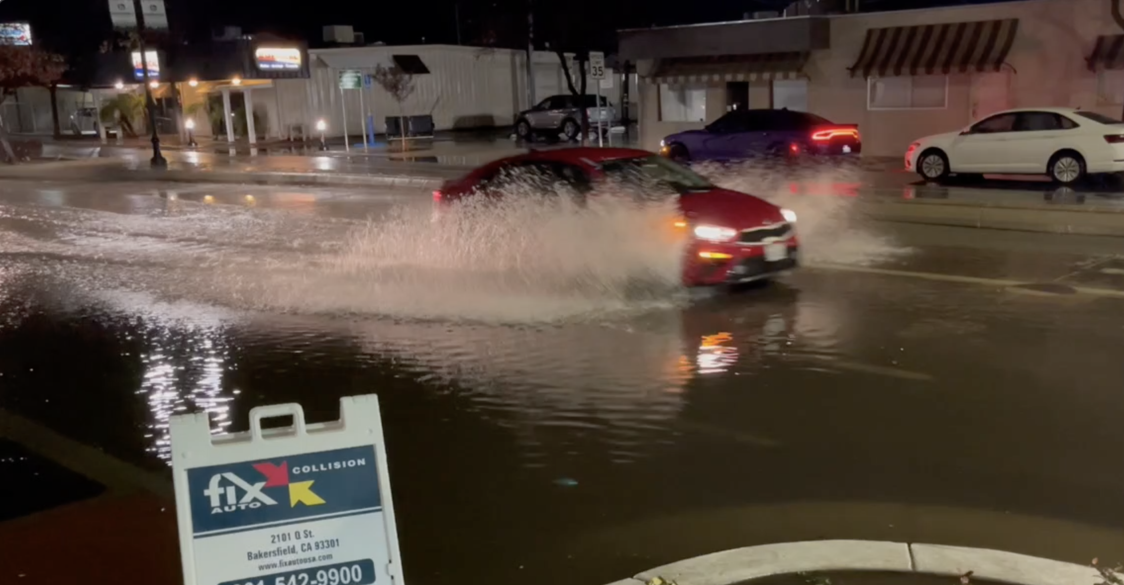 car in Bakersfield goes down a flooded road