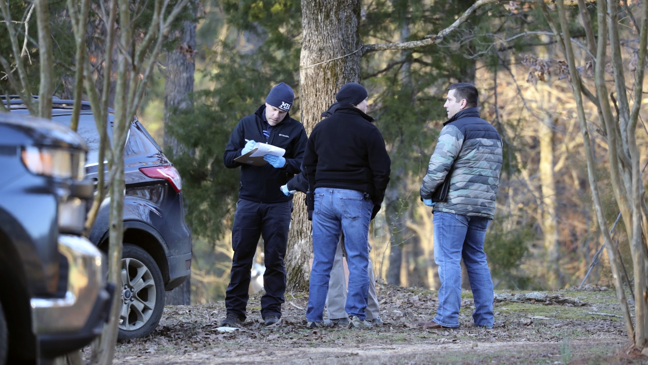 Law enforcement personnel investigate the scene of multiple shootings on Arkabutla Dam Road in Arkabutla, Miss