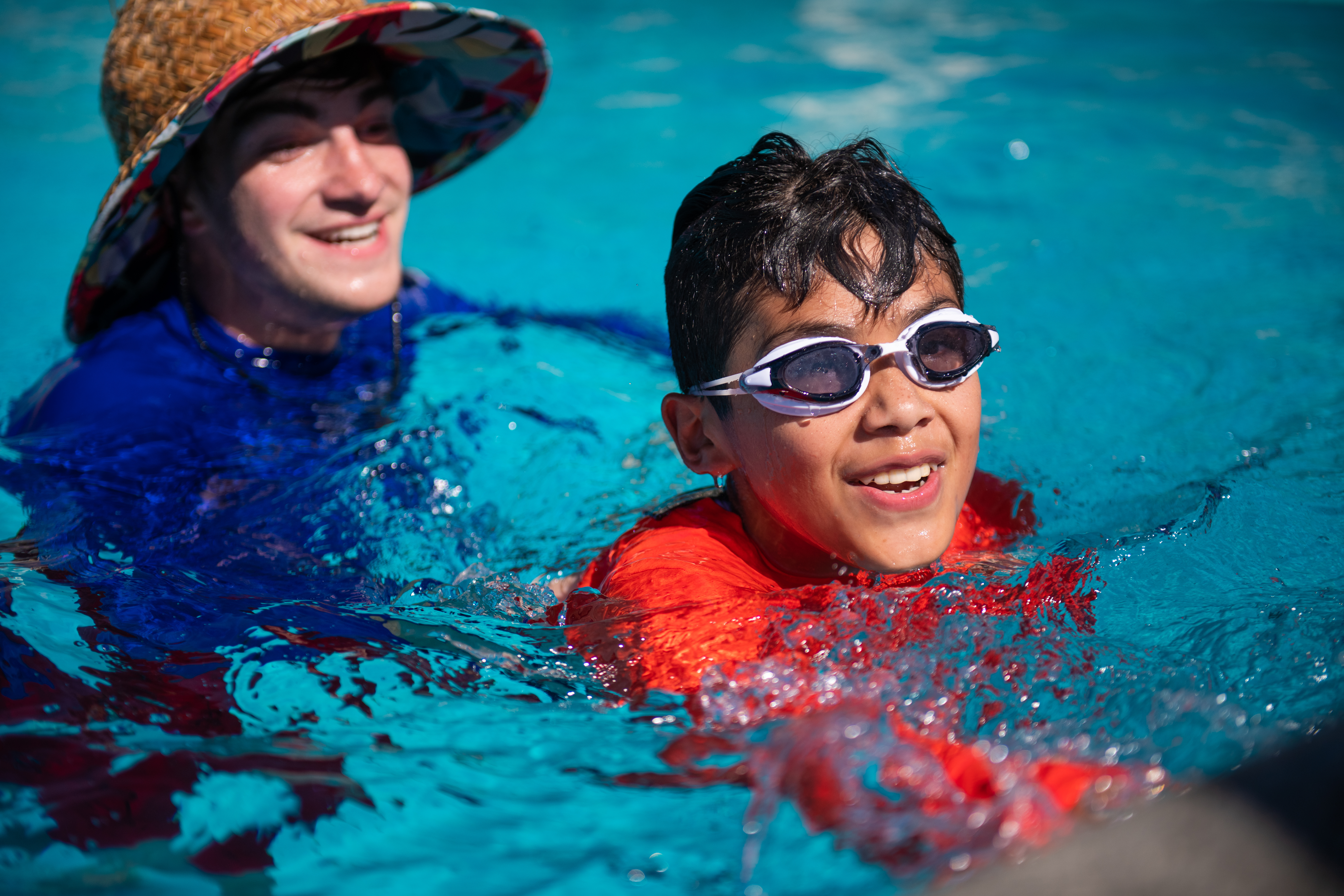 John teaching a boy with goggles in the pool.jpg