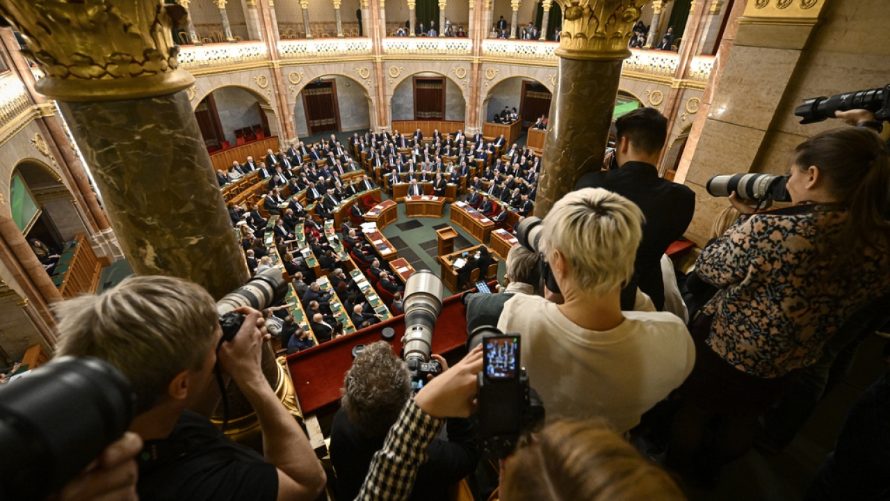 Photographers take pictures as Hungarian Prime Minister Viktor Orban stands after addressing a parliament session