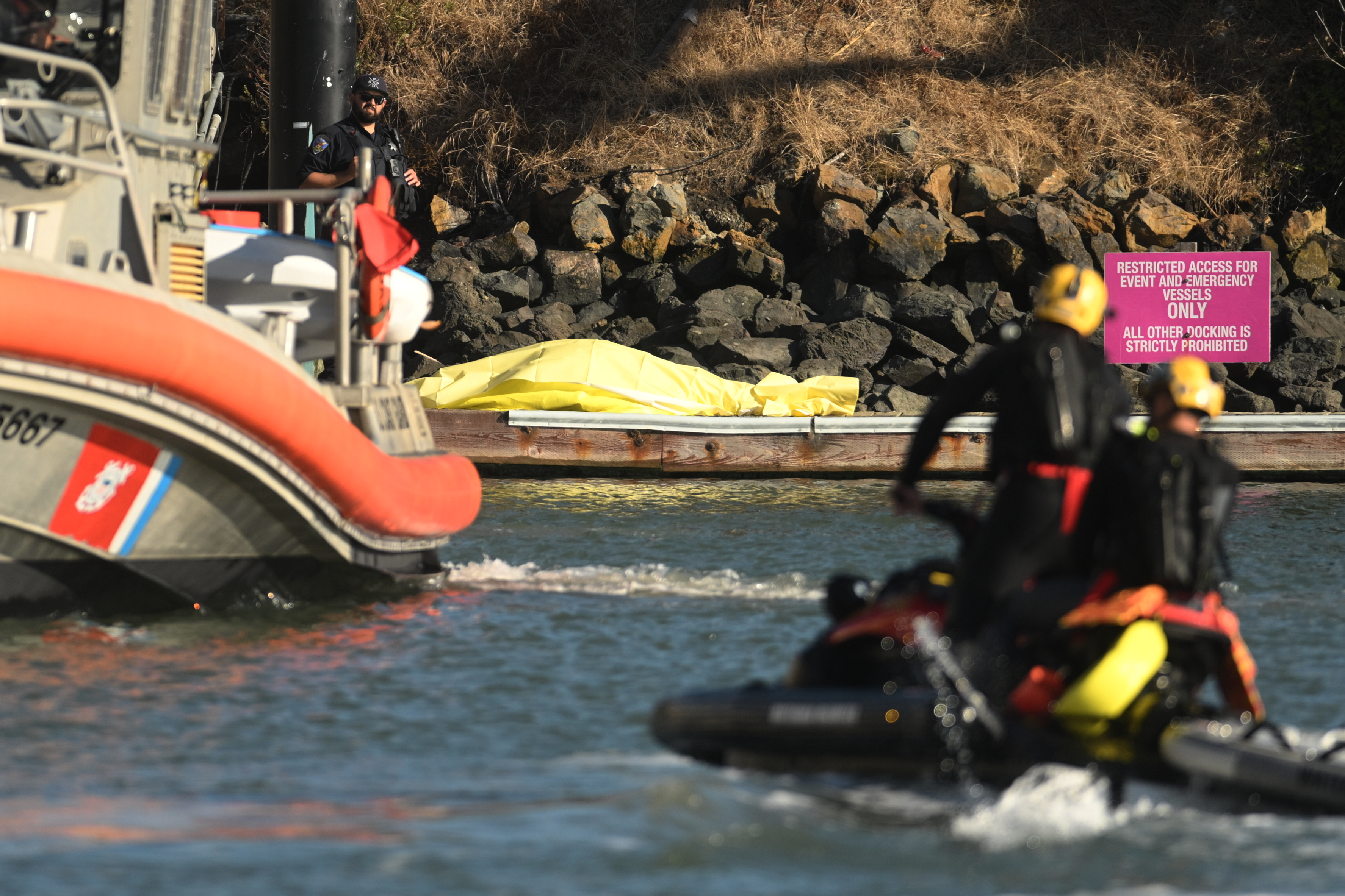 A body is covered with a tarp on a dock near the site of boat accident on Tuesday, July 14, 2026, in San Francisco.
