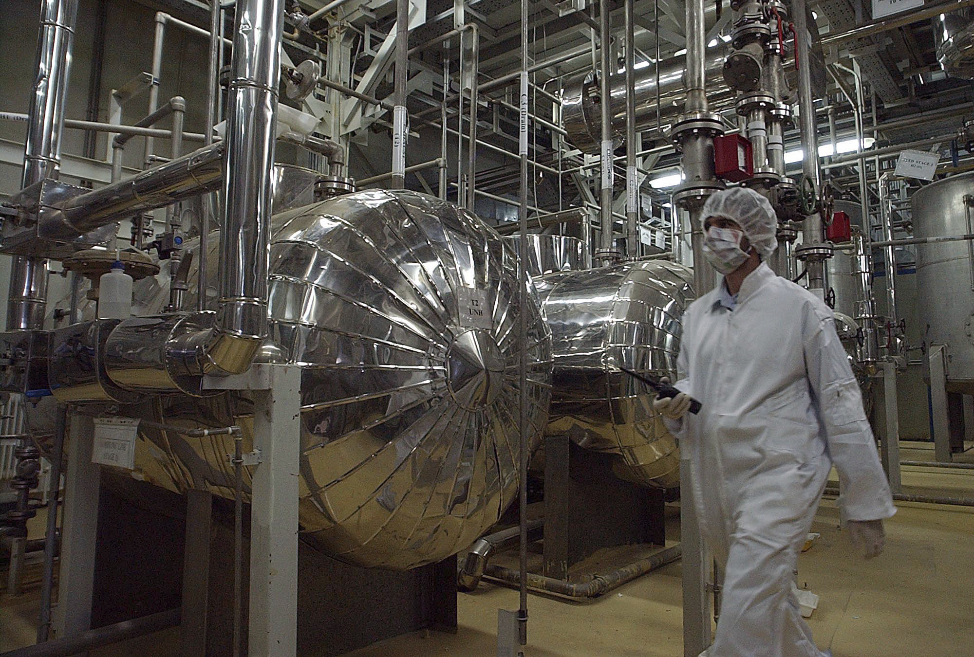 An Iranian security official in protective clothing walks through part of the Uranium Conversion Facility just outside the Iranian city of Isfahan, March 30, 2005.
