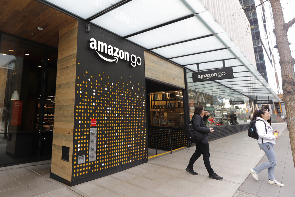 In this March 4, 2020 file photo, people walk out of an Amazon Go store, in Seattle. 