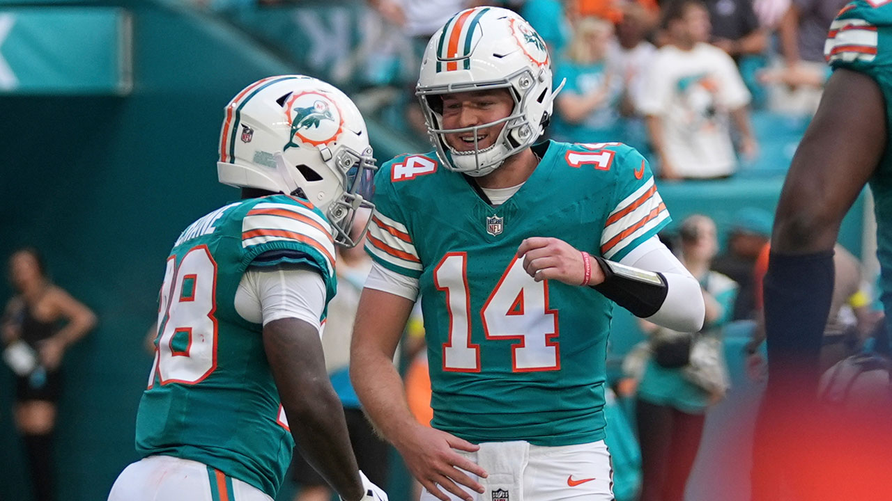 Miami Dolphins running back De'Von Achane, left, celebrates his touchdown with quarterback Quinn Ewers during the first half of an NFL football game against the Cincinnati Bengals, Sunday, Dec. 21, 2025, in Miami Gardens, Fla.