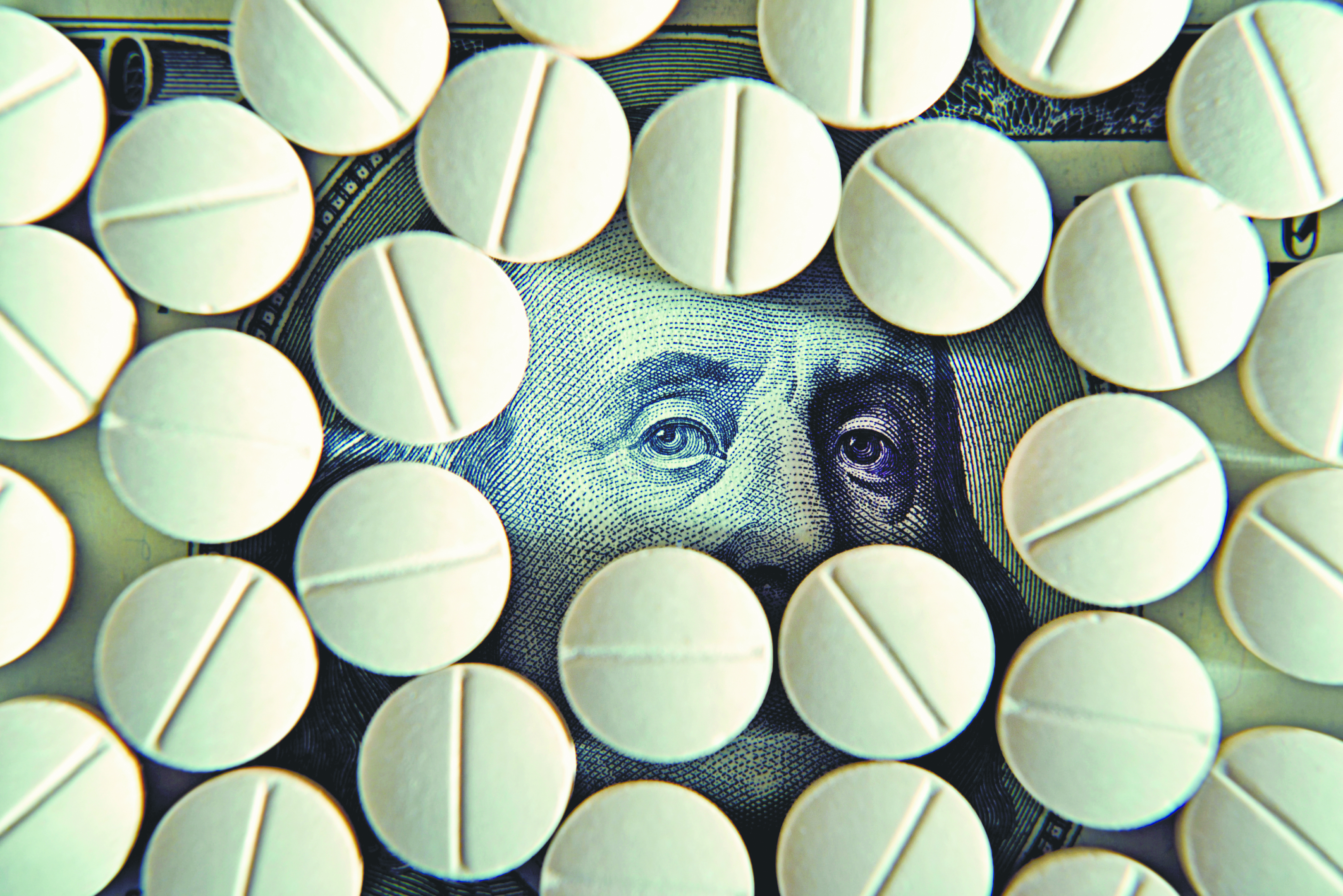 Tablets on dollar bills (treatment, addiction, aging - concept).