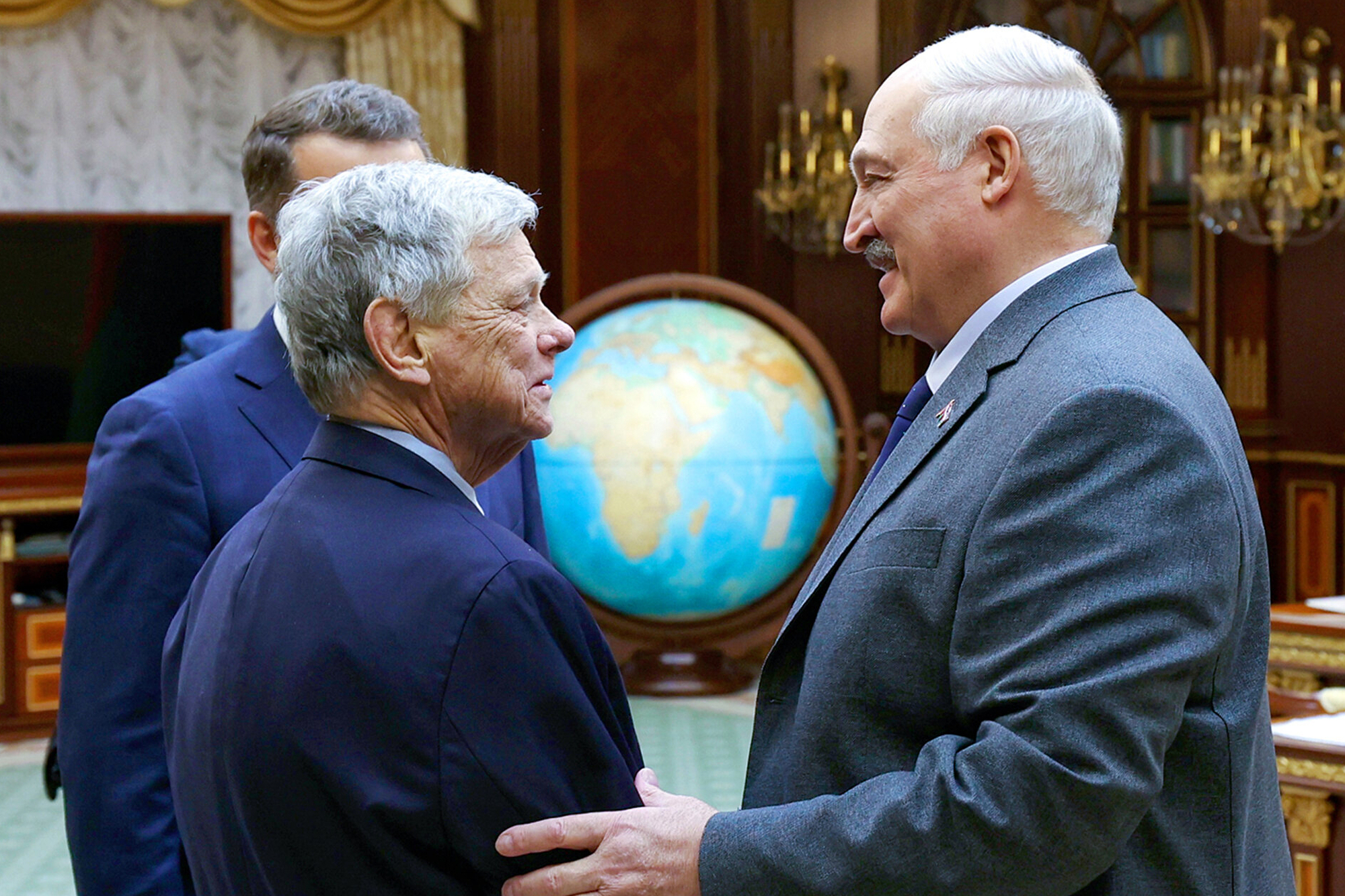 In this photo released by Belarusian presidential press service, Belarusian President Alexander Lukashenko, right, and U.S. Presidential envoy John Coale shake hands during their meeting in Minsk, Belarus, Friday, Dec. 12, 2025.