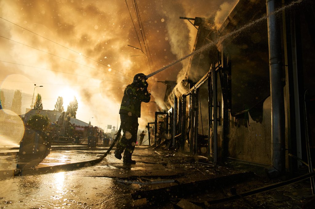 Firefighters try to put out a fire at a city book market following a Russian missile attack in Kyiv, Ukraine, early Sunday, Aug. 16, 2026. 