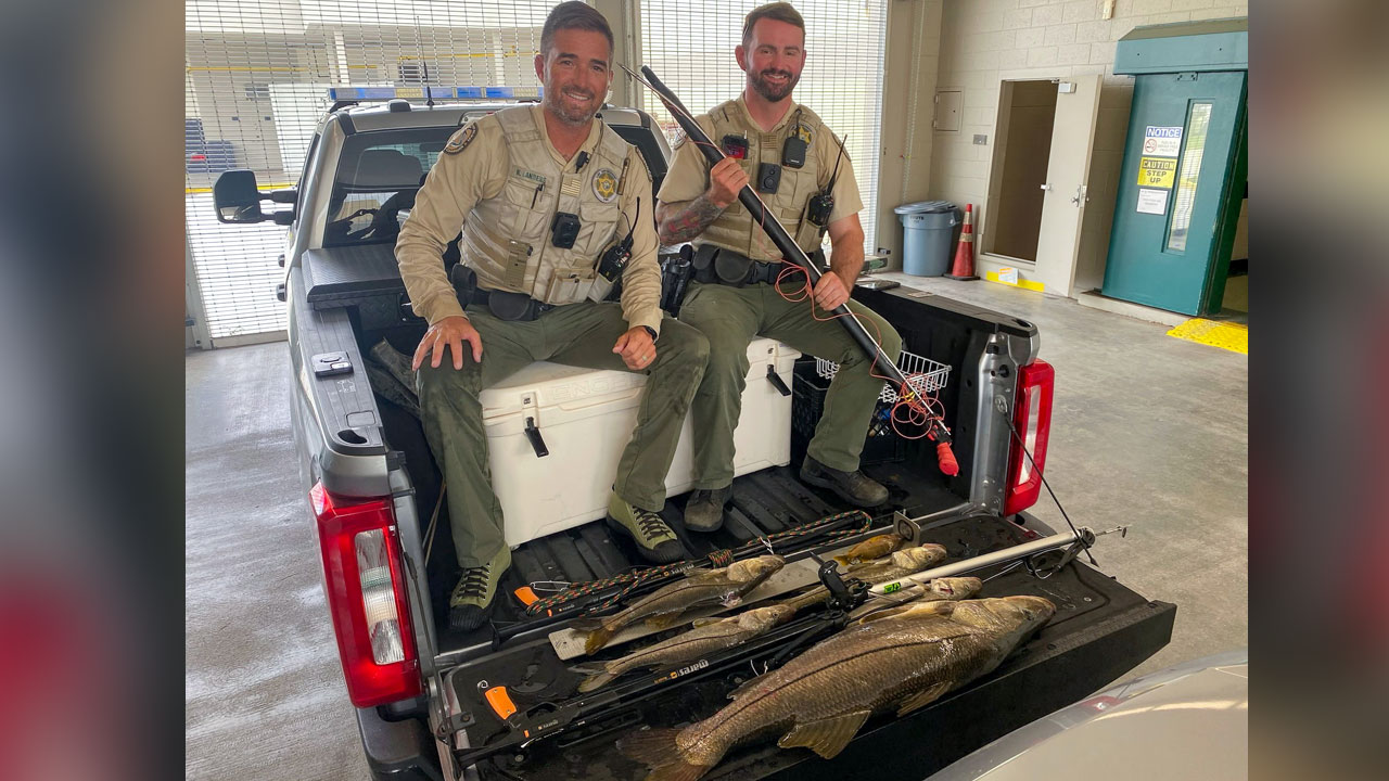 FWC officers pose with fish seized in an alleged case of illegal spearfishing on July 6, 2025, in Martin County.