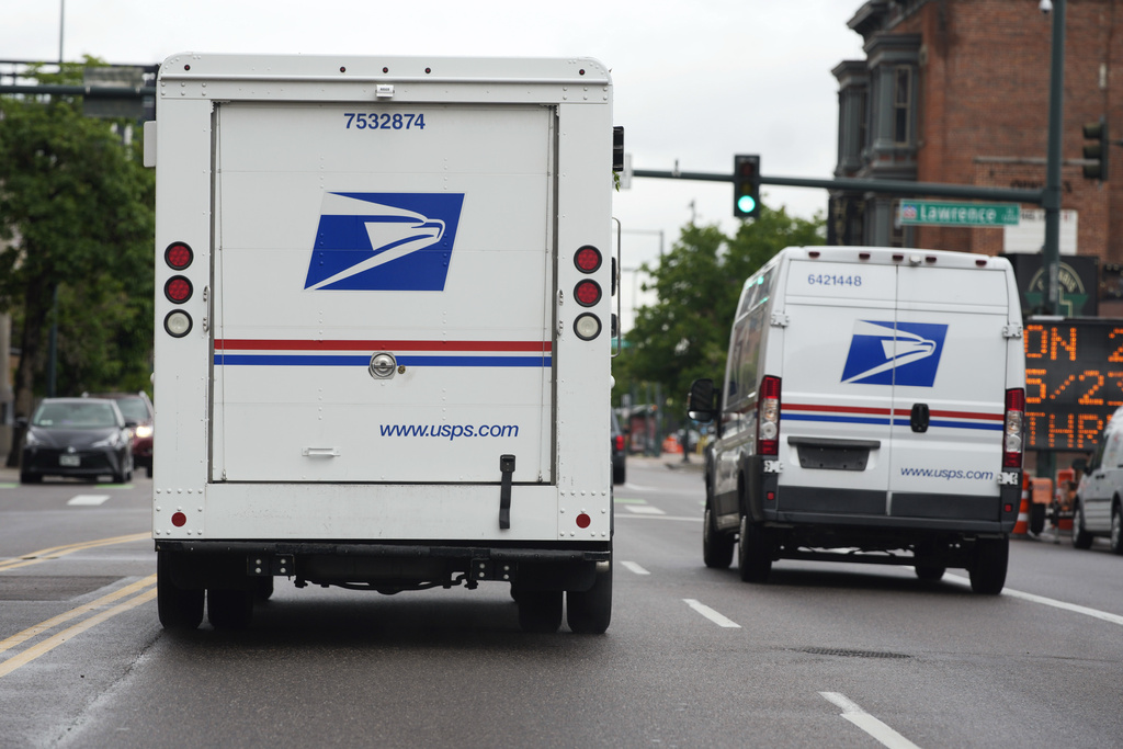 A USPS logo adorns the back doors of United States Postal Service delivery vehicles.
