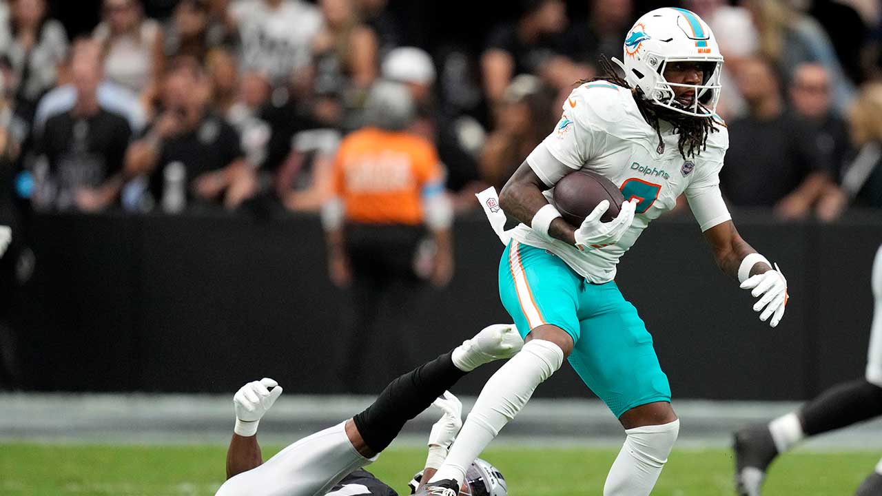 Miami Dolphins wide receiver Caleb Douglas (7) breaks a tackle by Las Vegas Raiders safety Jeremy Chinn (11) after catching a pass during the first half of an NFL football game, Sunday, Sept. 13, 2026, in Las Vegas.