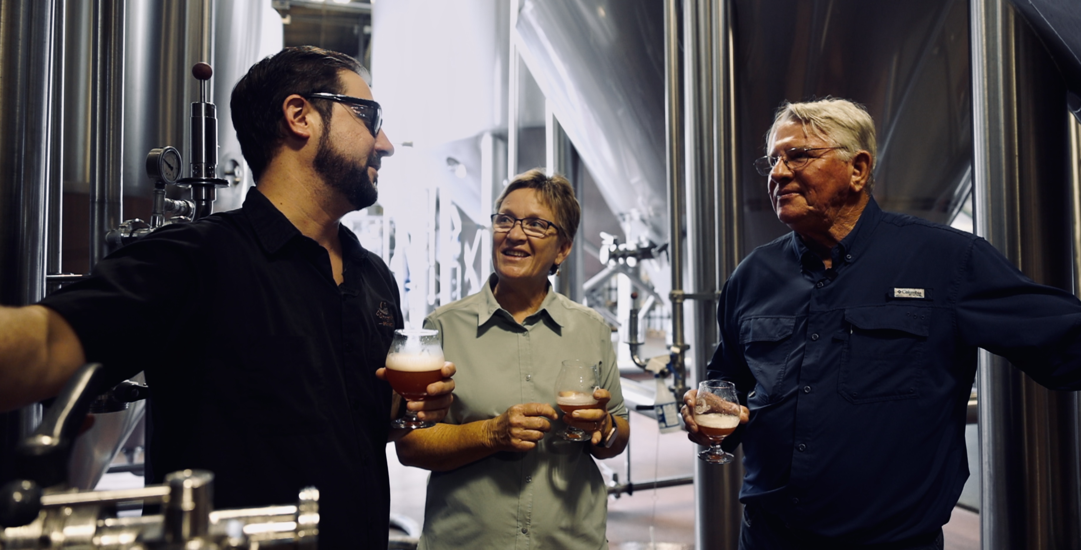 Sam Swartz at Coppertail Brewing giving Ann and Gene Altman a taste of a seasonal beer made with the couple's blackberry-infused beer