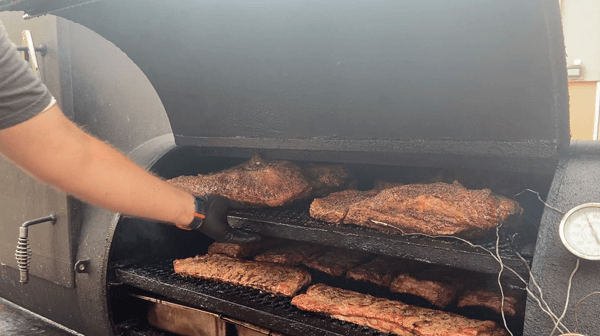 Crossroads Barbecue, spraying meat with olive oil. 