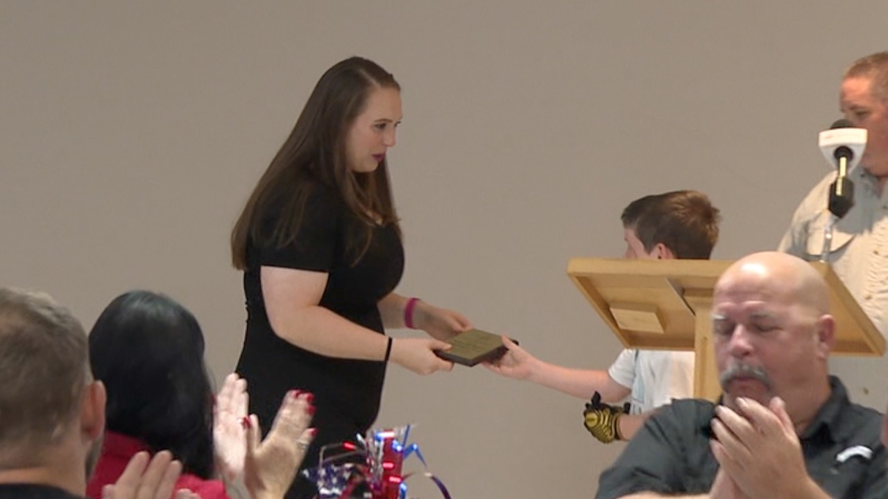 JuliaAnne Harvey accepting the Firefighter/Paramedic of the Year Award from Sawyer Crawley