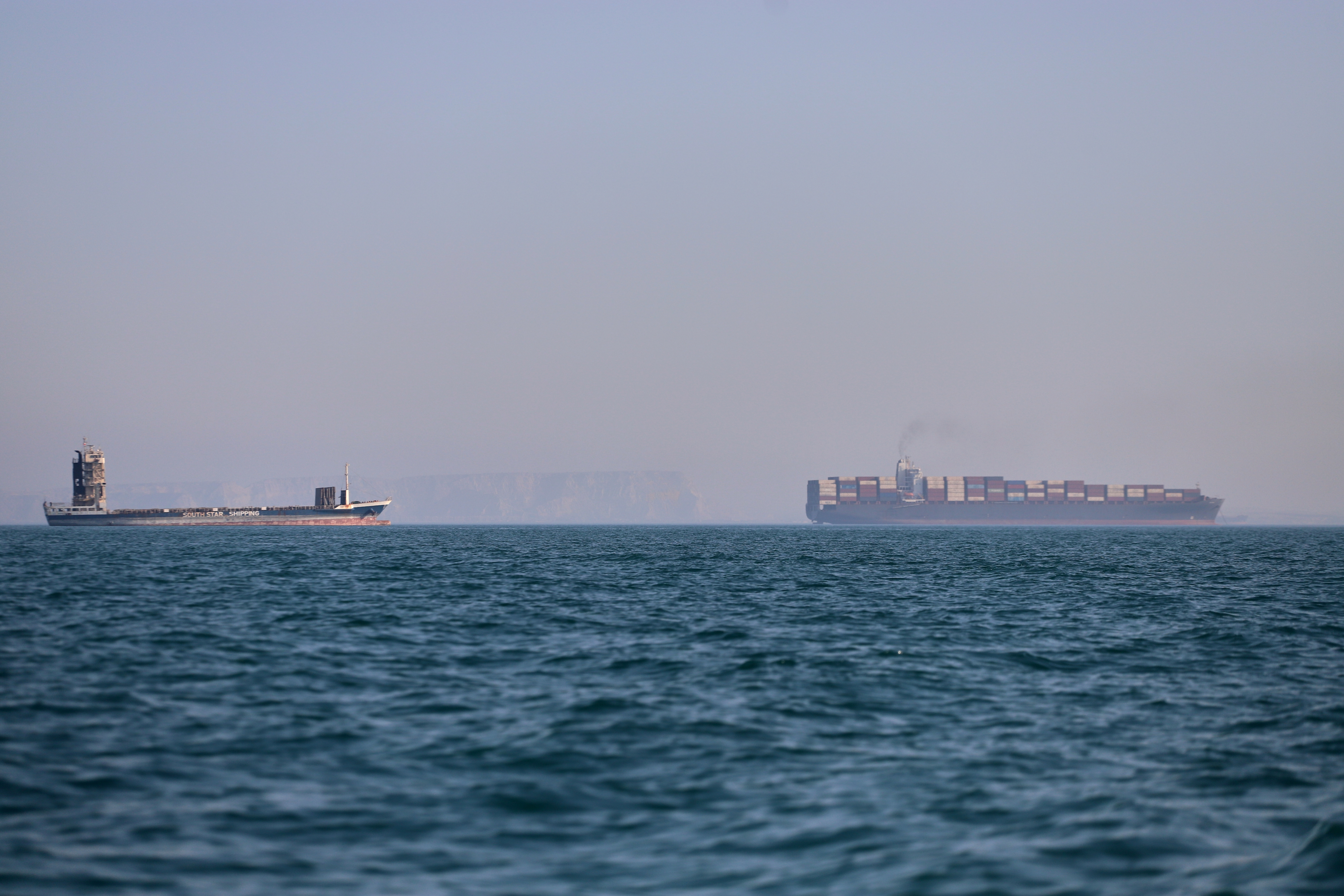 A container ship, right, and a cargo vessel are seen in the Strait of Hormuz off Bandar Abbas, Iran, Wednesday, June 17, 2026.