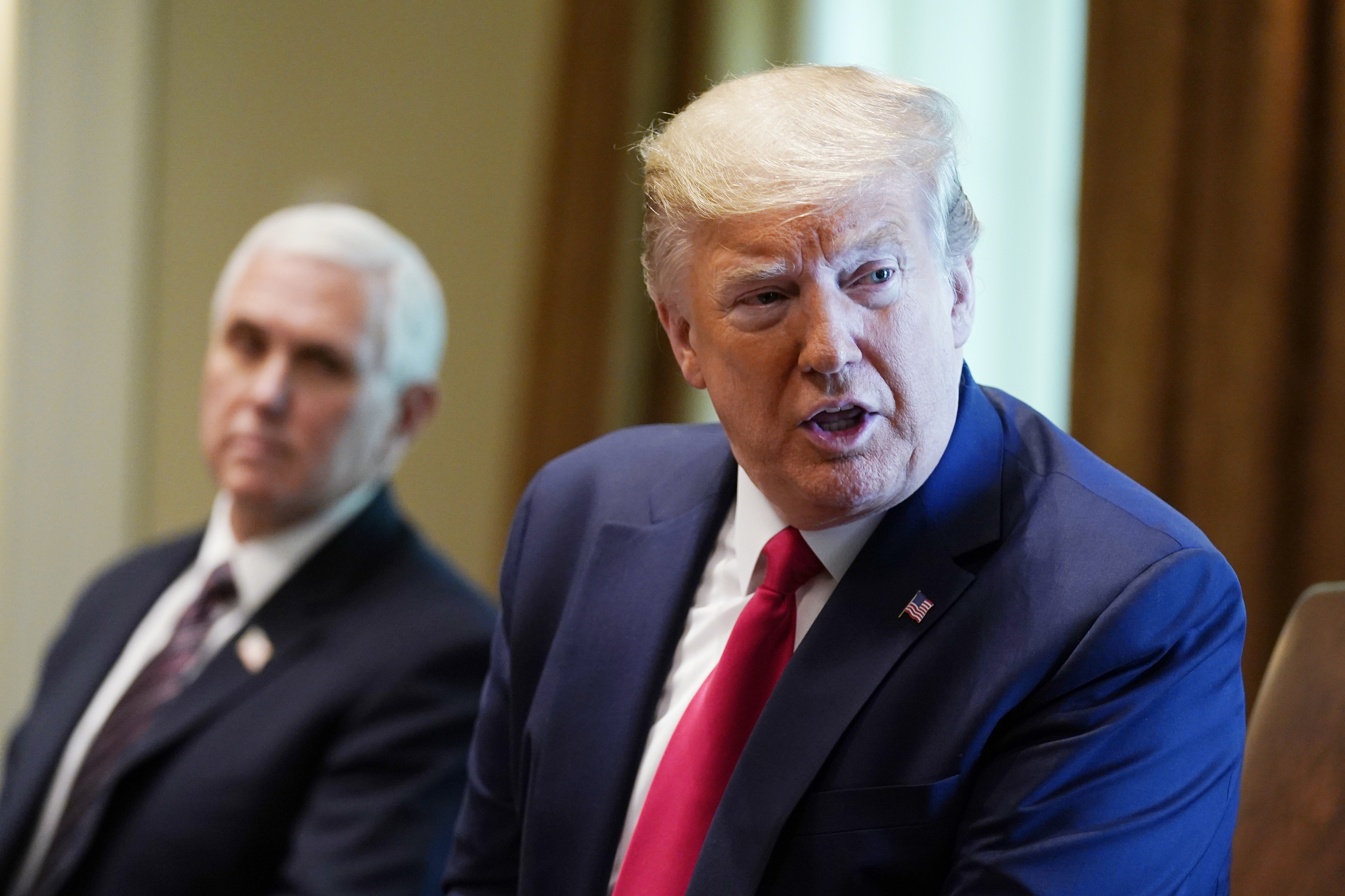 President Donald Trump and VP Mike Pence in background meeting with recovered coronavirus patients