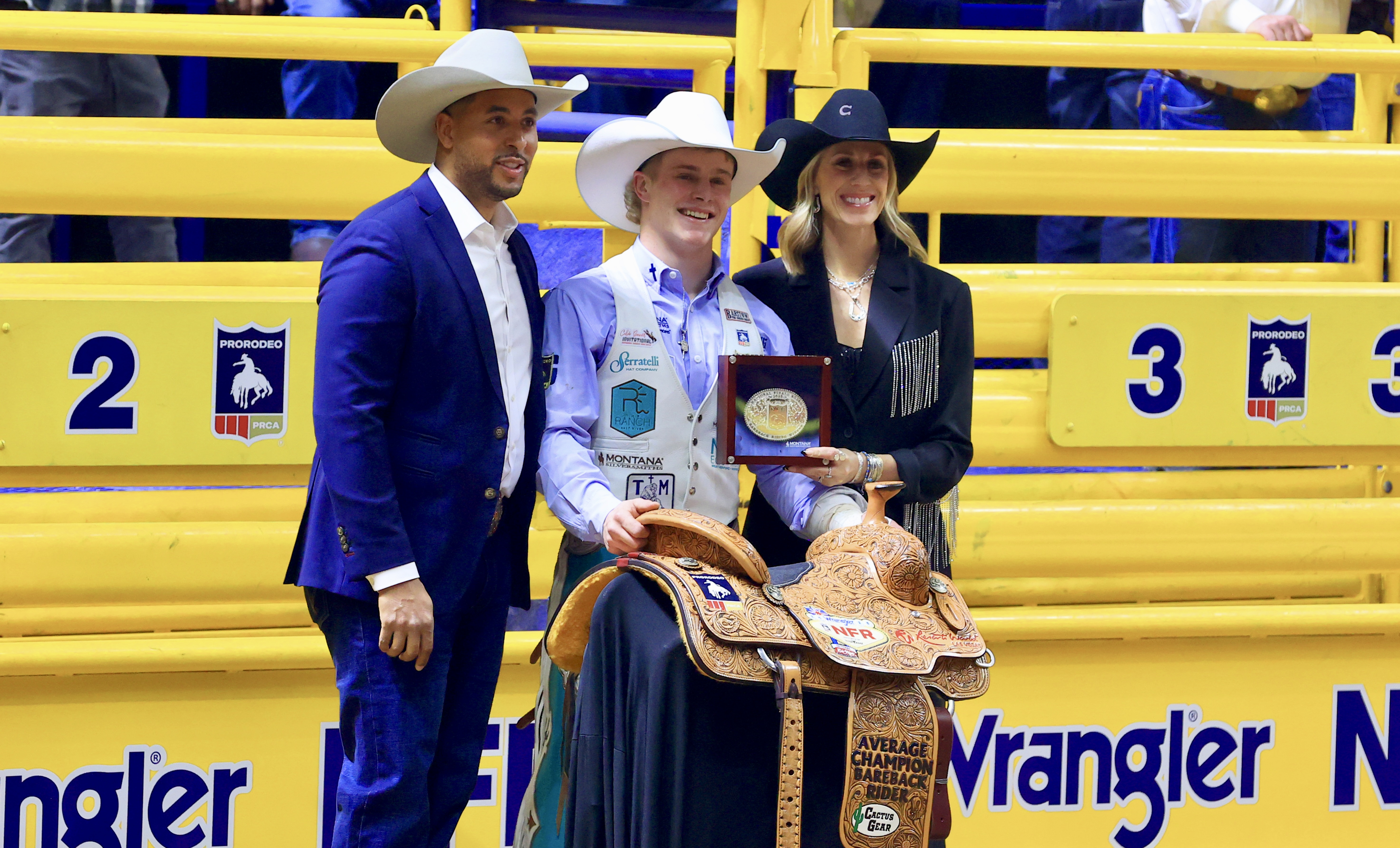 Sam Petersen presented with the buckle and saddle for winning the NFR average title in the bareback