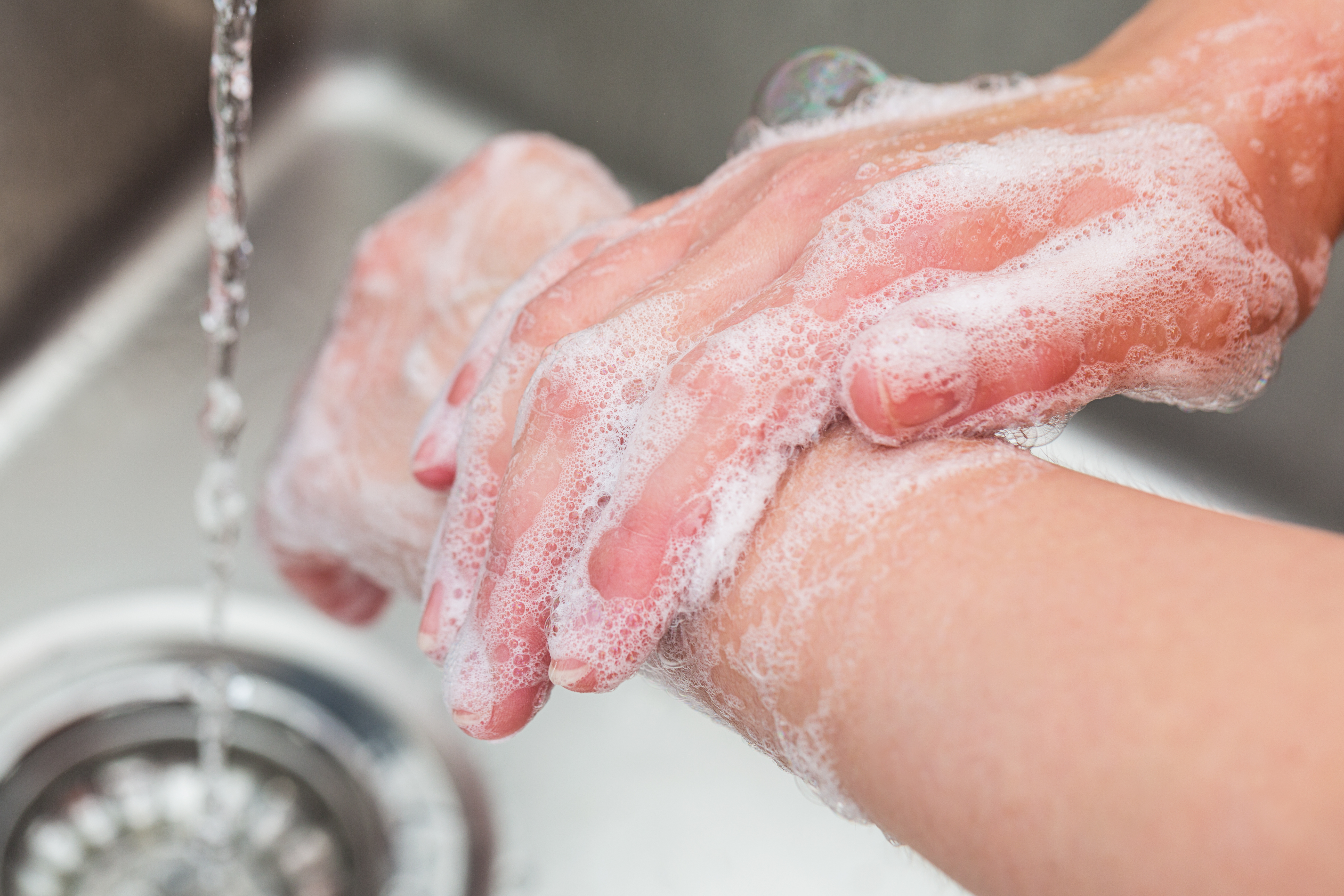 A person washes their hands with soap