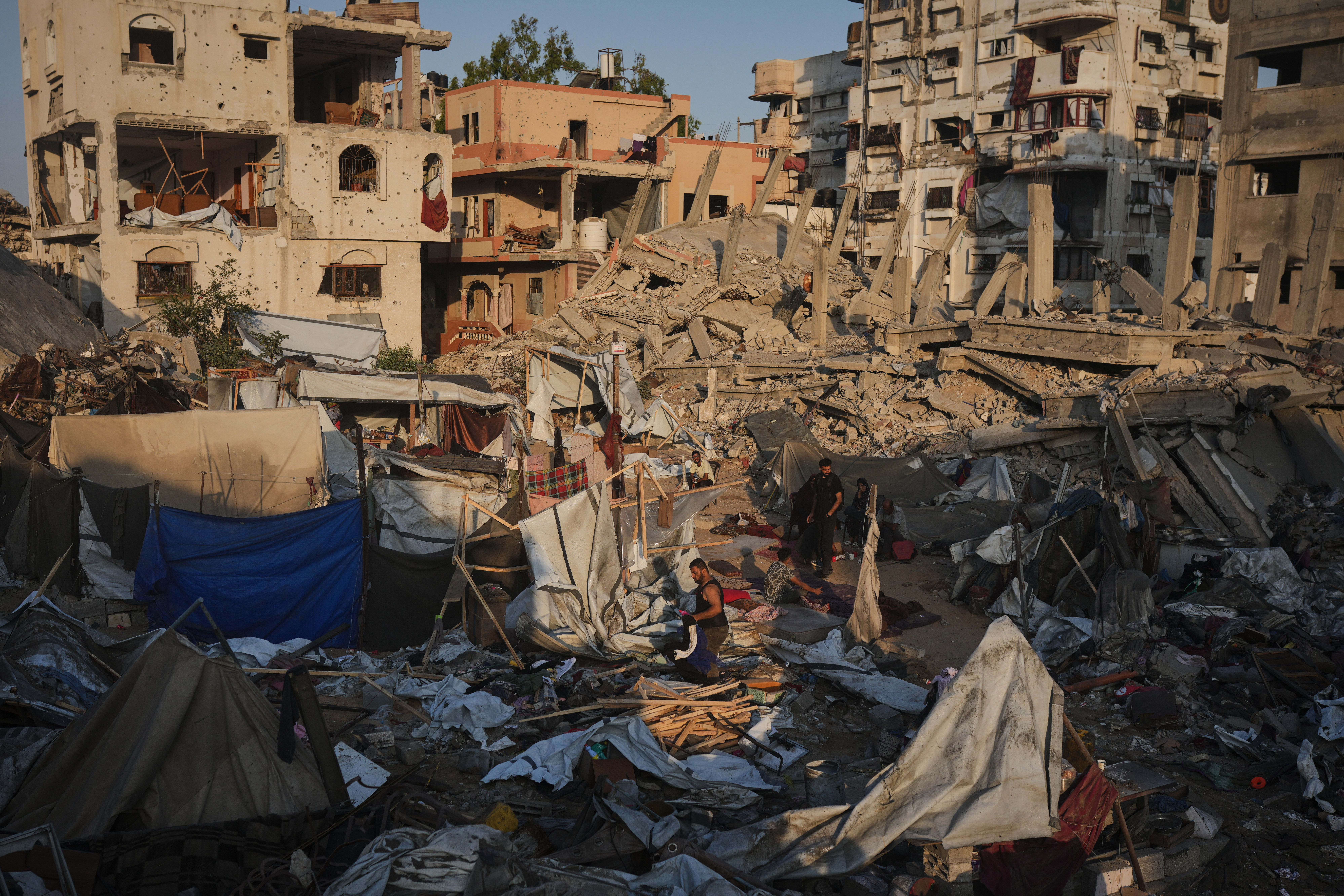 Palestinians salvage their belongings from the rubble of a building and tents destroyed in an Israeli airstrike in Gaza City, Thursday, July 30, 2026.