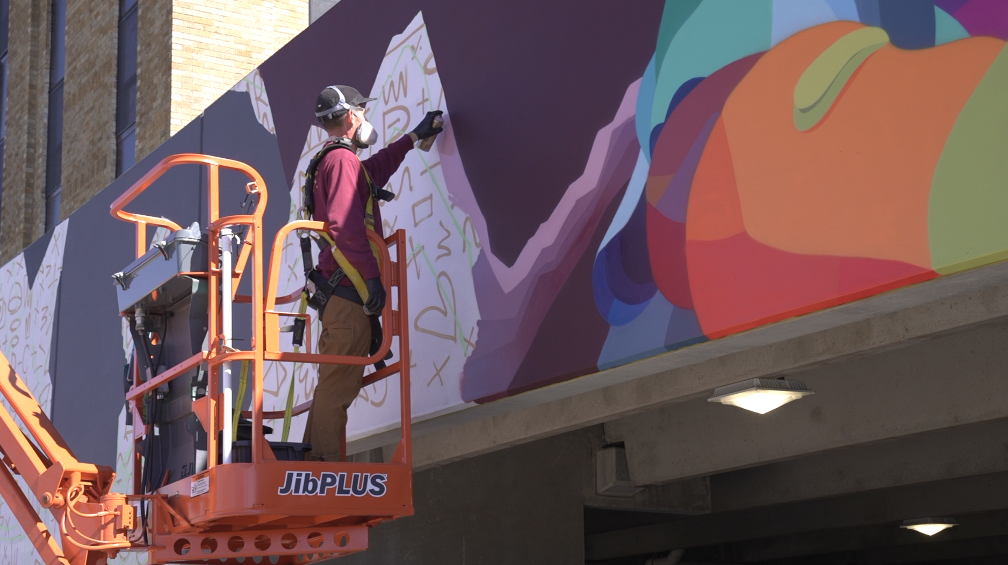 Dustin Hunt working on a mural in Old Town 