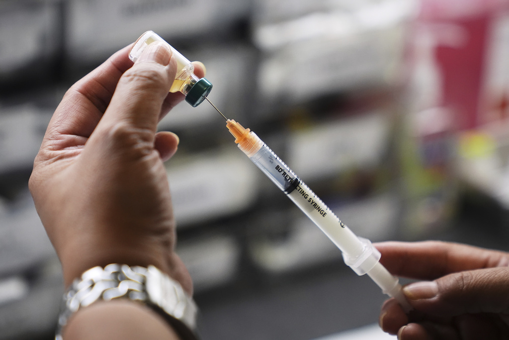 Medical professional prepares a dose of the measles, mumps and rubella (MMR) vaccine.
