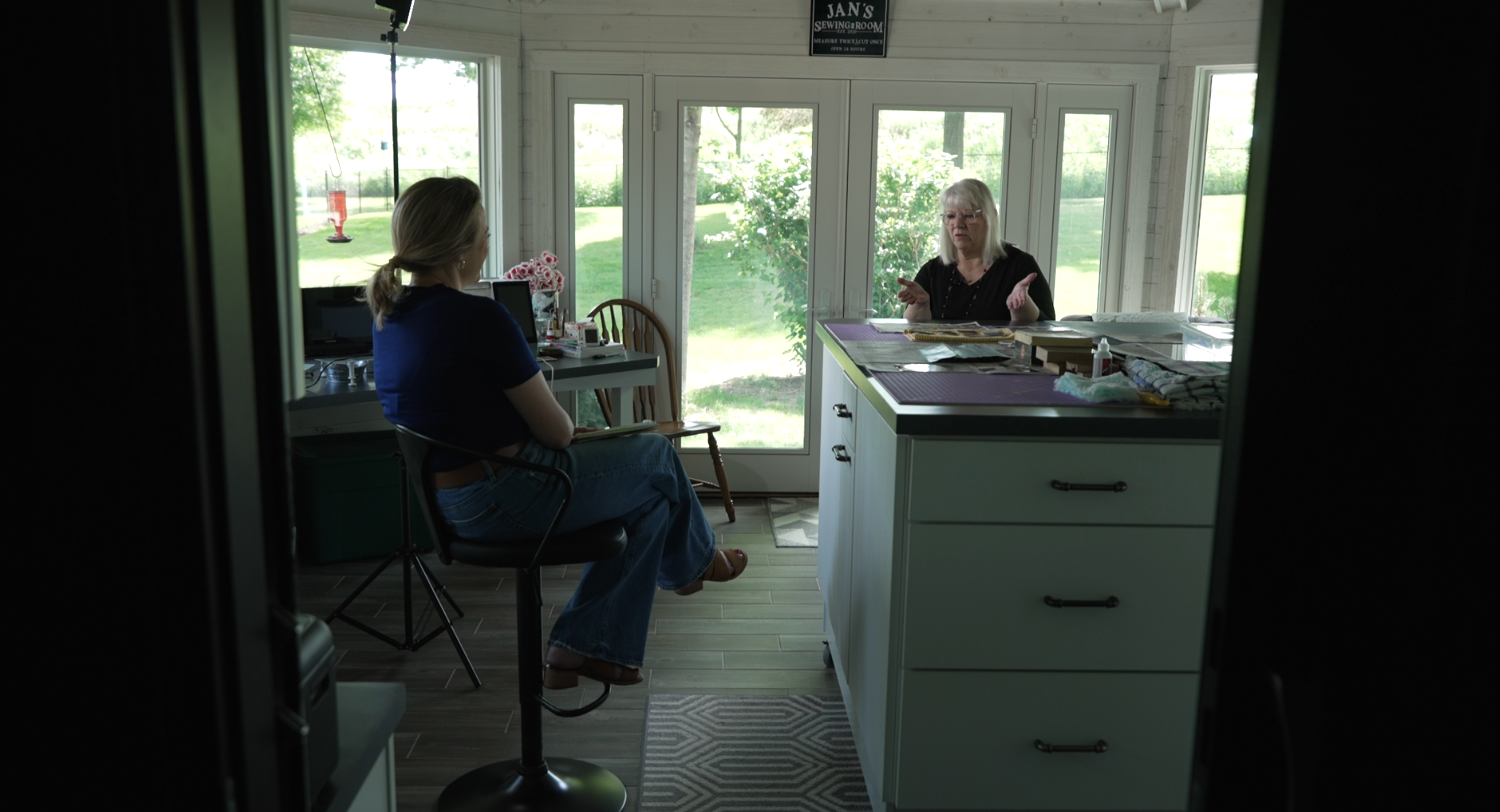 3 News Now's Mary Nelson, left, speaks to Jan Zanders inside her photo digitizing lab (and quilting room).