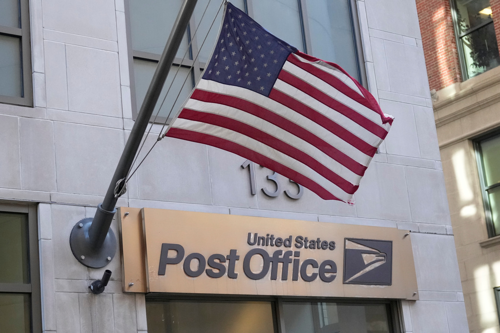 The flag flies outside a U.S. Post Office branch, Monday, Nov. 24, 2025, in Boston. 