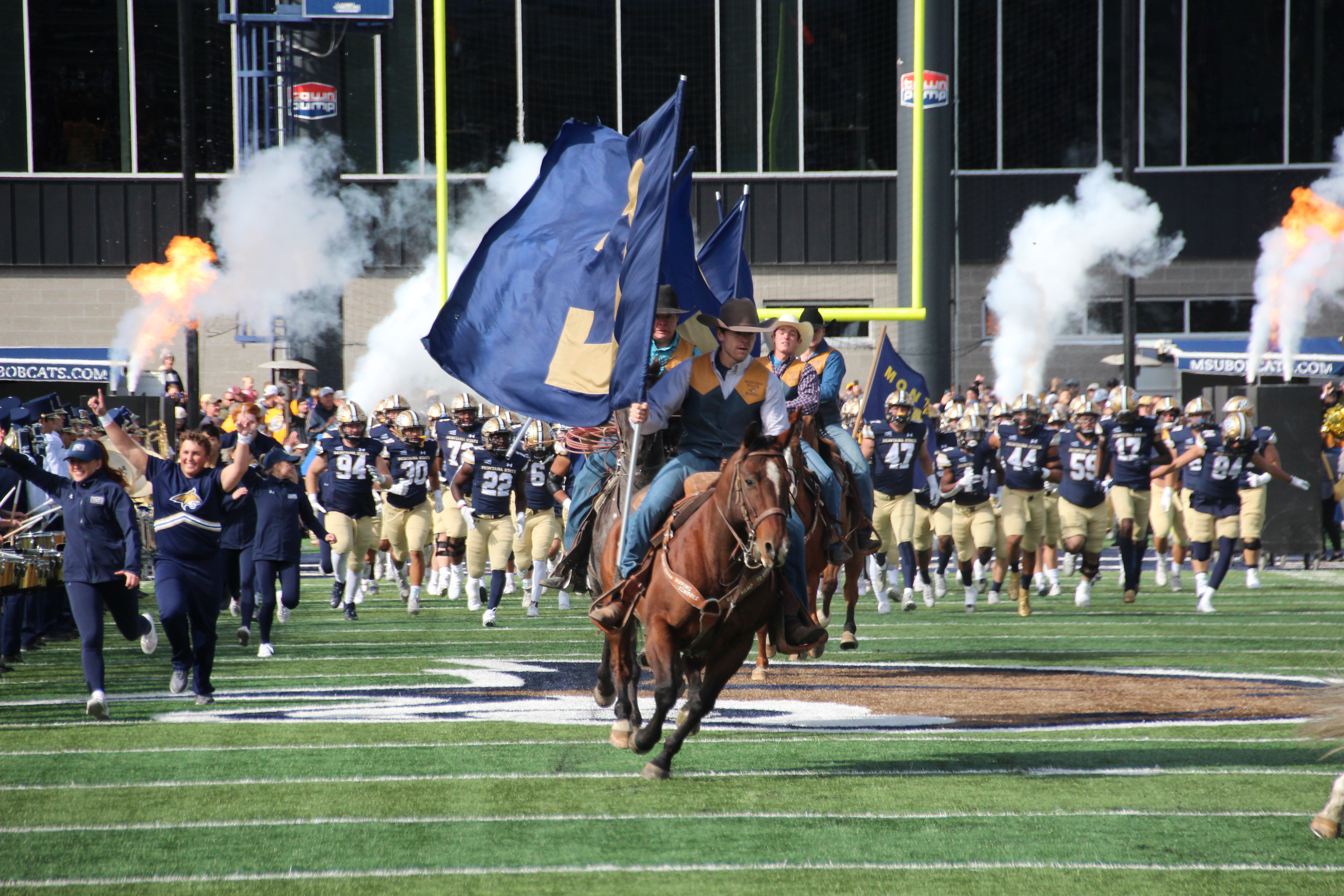 Montana State rodeo team rides in before the game