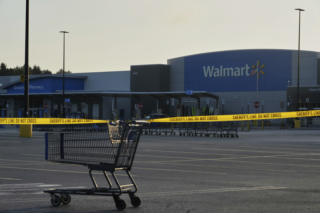 A shopping cart anchors police tape outside a Walmart where multiple people were stabbed in a violent attack Saturday, July 26, 2025, in Traverse City, Mich.