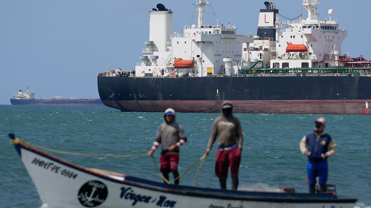 FILE - Fishermen pass an oil tanker in the Gulf of Venezuela off the shore of Punta Cardon, Venezuela, Jan. 14, 2026. (AP Photo/Matias Delacroix, File)