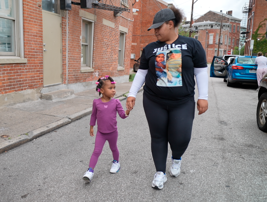 De'Nashia Shepard walks with her 4-year-old daughter outside the Over-the-Rhine building where her two infant children died in the past two years, she believes due to toxic mold exposure.