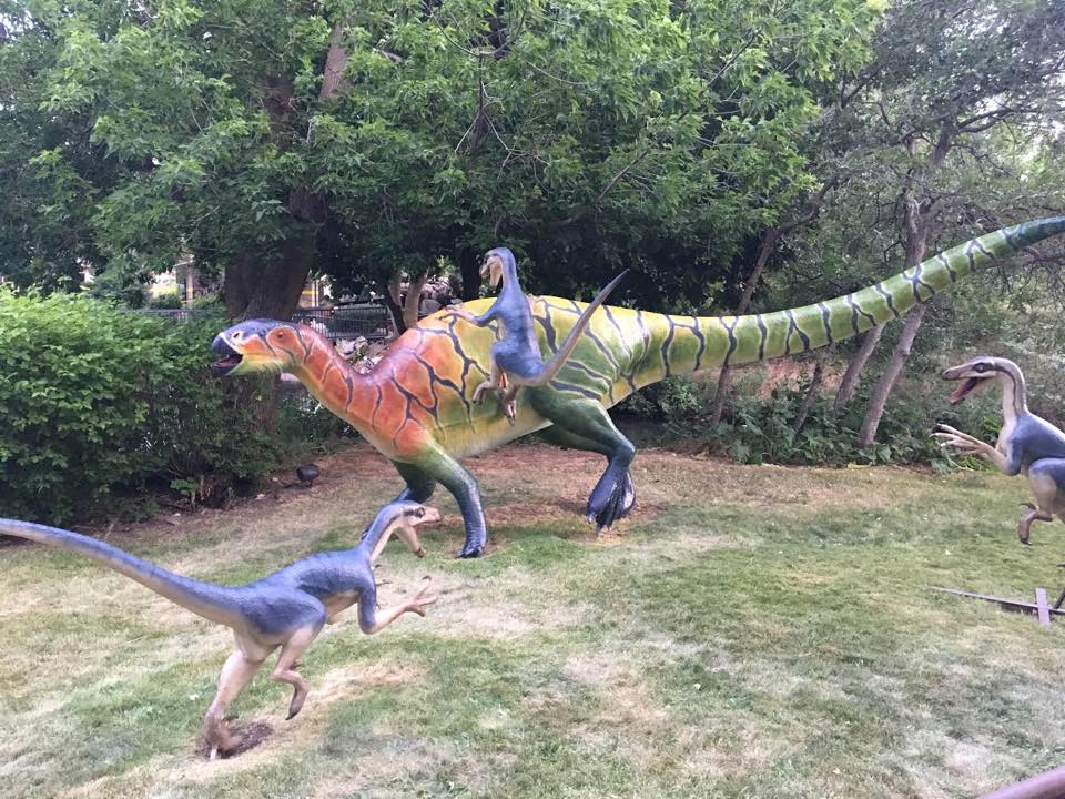 Sculptures at Eccles Dinosaur Park in Ogden, Utah show three raptors attacking a larger dinosaur