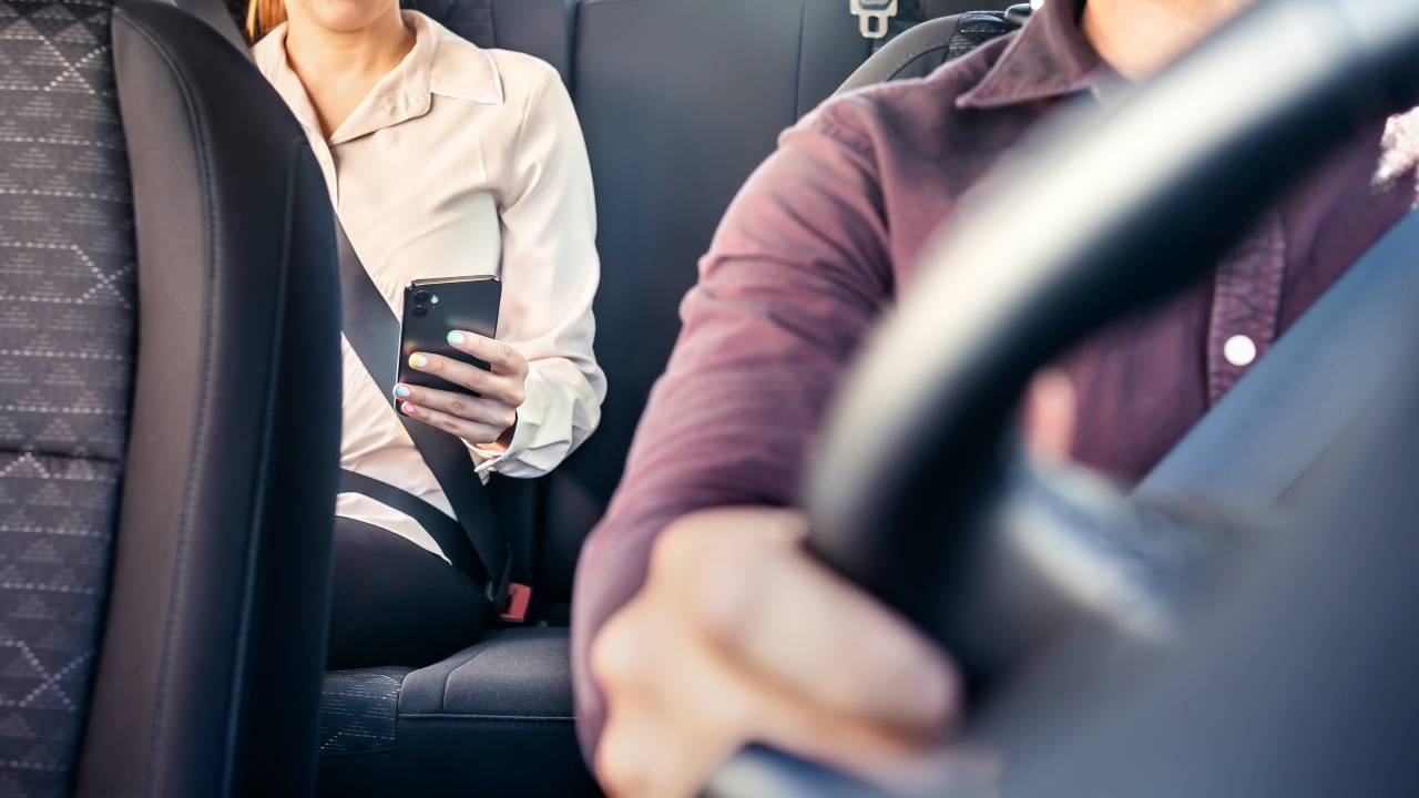 A driver and a backseat passenger are shown.