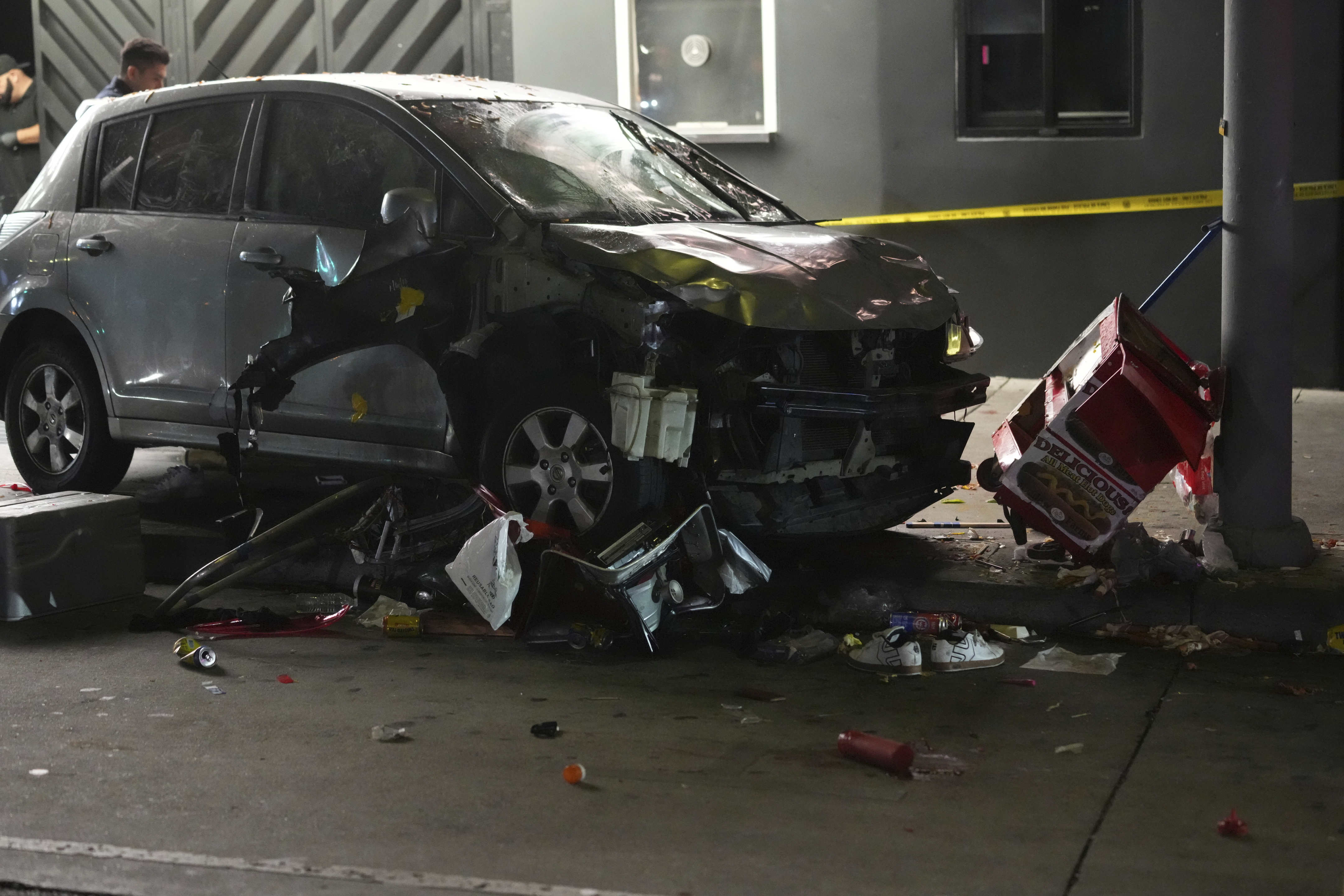 A vehicle sits on the sidewalk after ramming into a crowd of people waiting to enter a nightclub along a busy boulevard in Los Angeles early Saturday, July 19, 2025 injuring several people. 