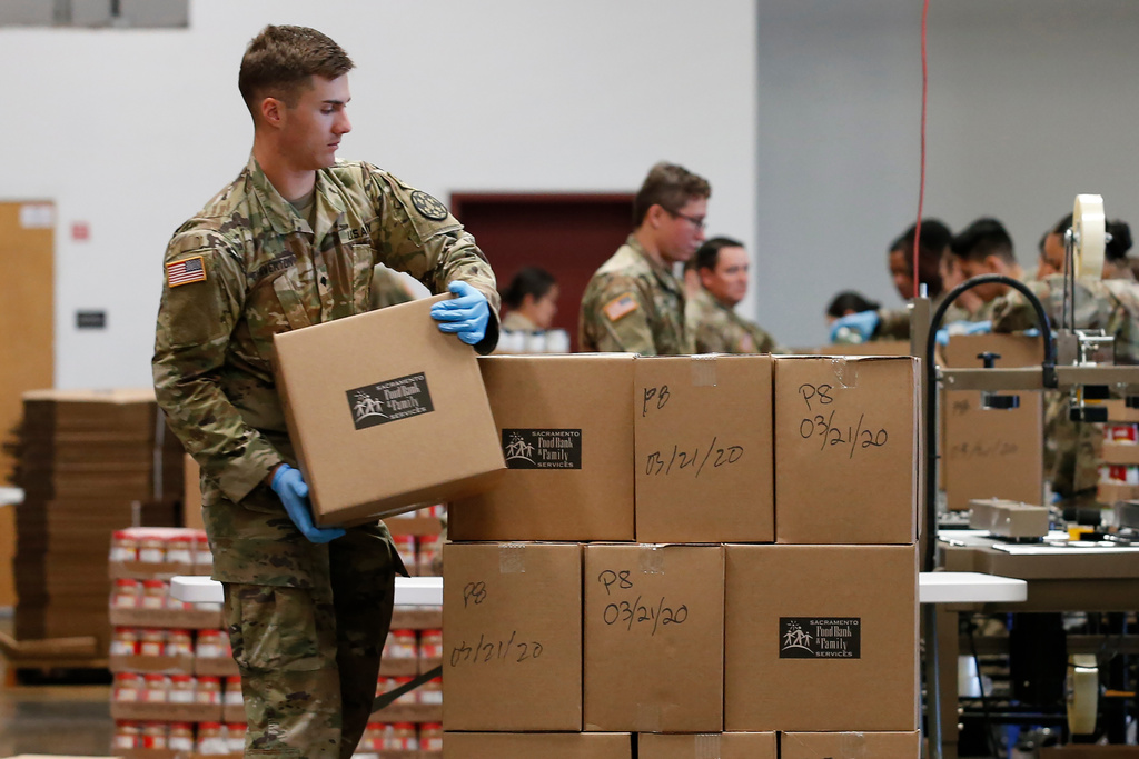 File photo shows Specialist Colby Chiverton, of the California National Guard, stacking boxes of food supplies at the Sacramento Food Bank and Family Services in Sacramento, Calif.