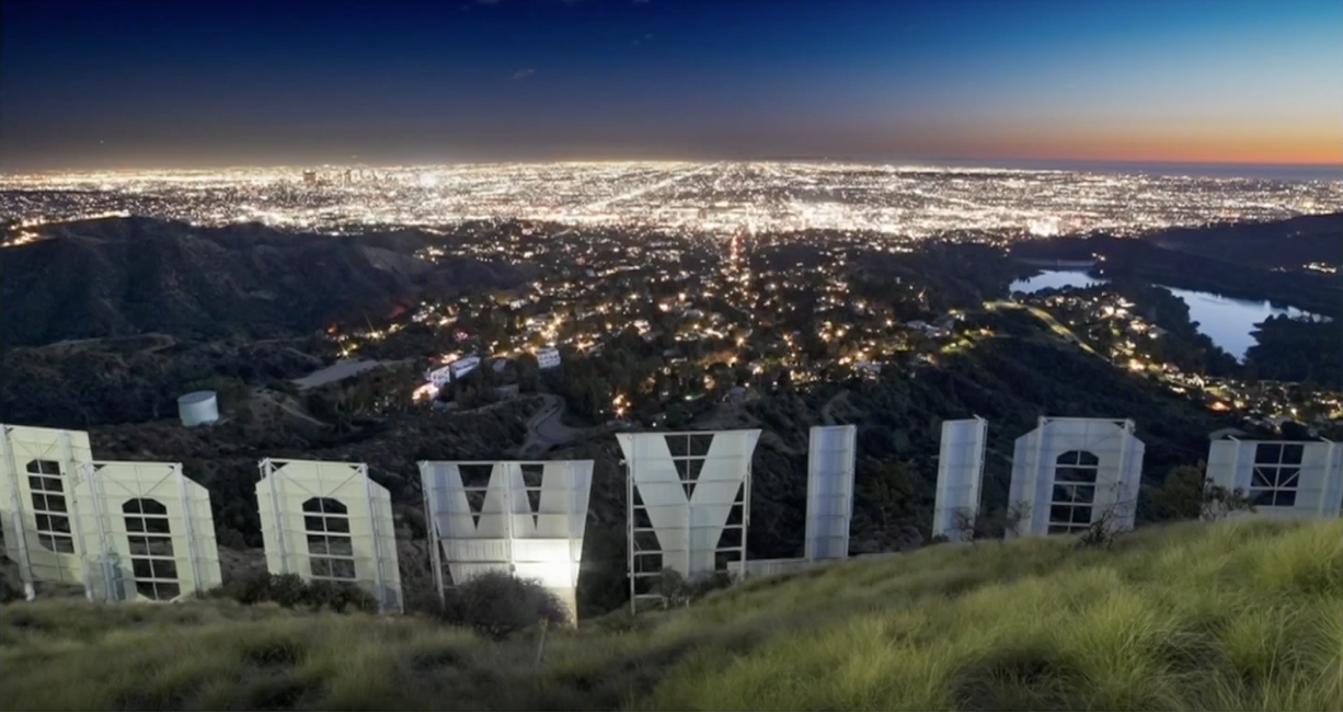 City lights seen in front of the Hollywood sign.