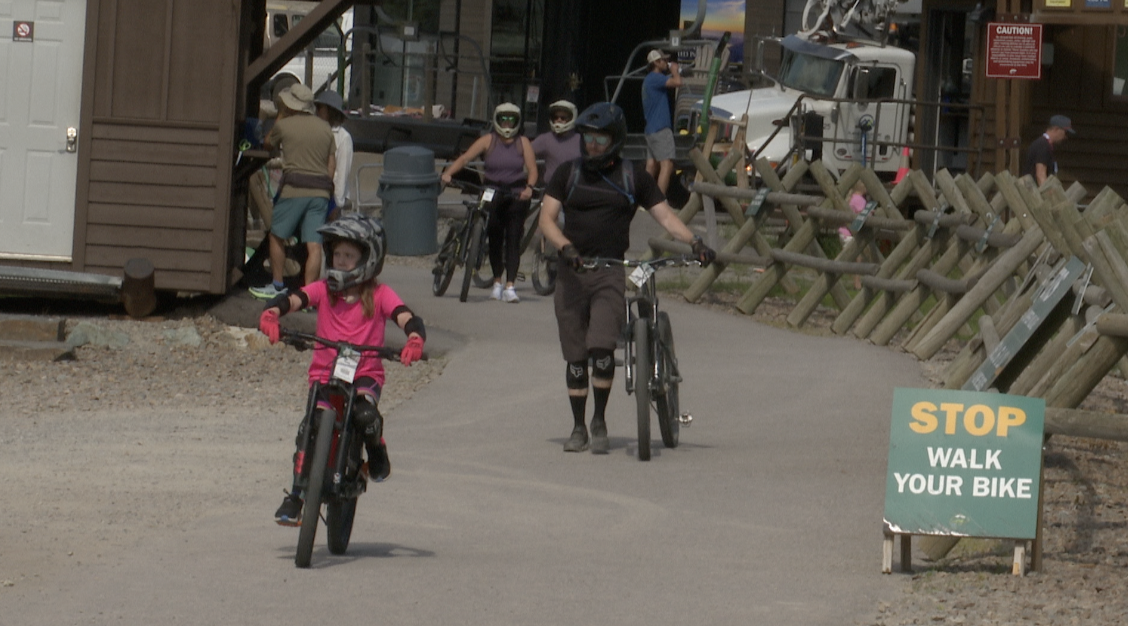 Tom Stith and his daughter preparing to ride down the mountain, Whitefish