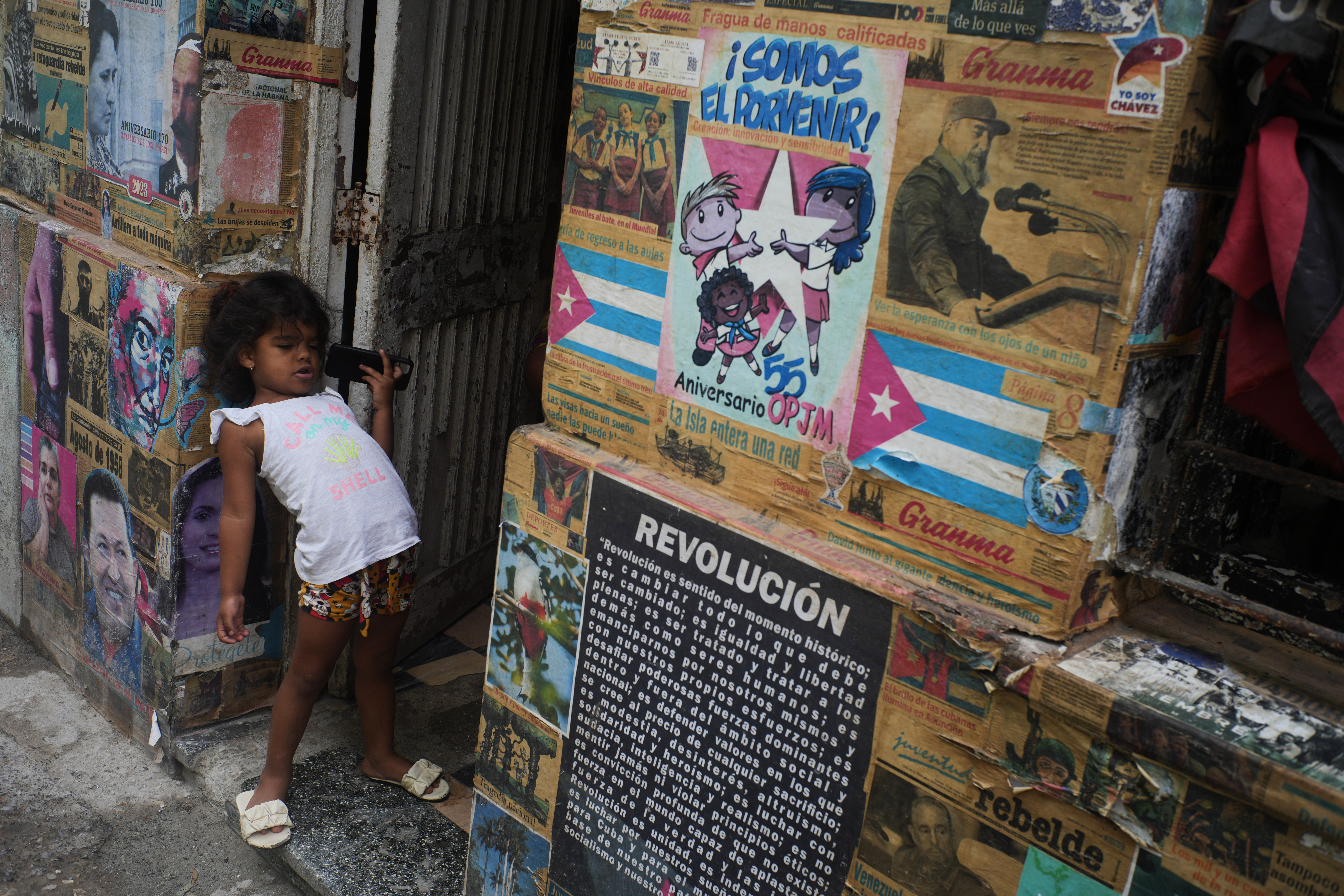 A girl plays in the doorway of the building where there is an art installation related to the Cuban Revolution, during a blackout in Havana, Tuesday, March 17, 2026. 