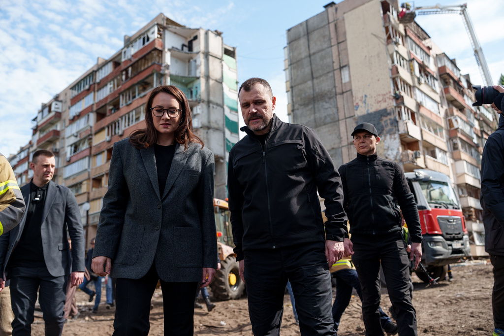 Ukraine's Prime Minister Yuliia Svyrydenko, left, and Ukraine's Interior Minister Ihor Klymenko, right, walk in the yard of an apartment building heavily damaged after a Russian strike on residential neighbourhood in Kyiv, Ukraine, on Friday, May 15, 2026. 
