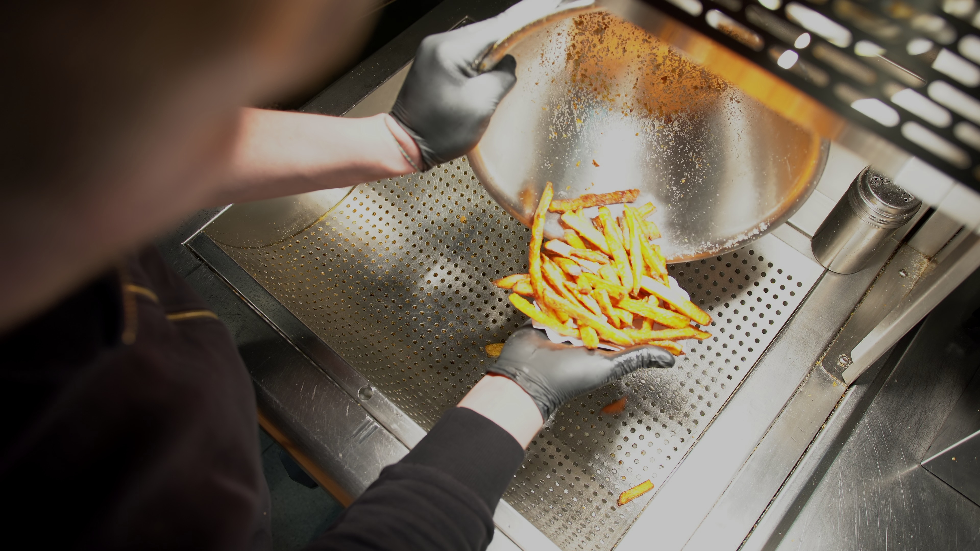 fast-food-worker-making-a-serving-of-french-fries-overhead-view-of-fast-food-worker-ad-SBI-350683082.jpg
