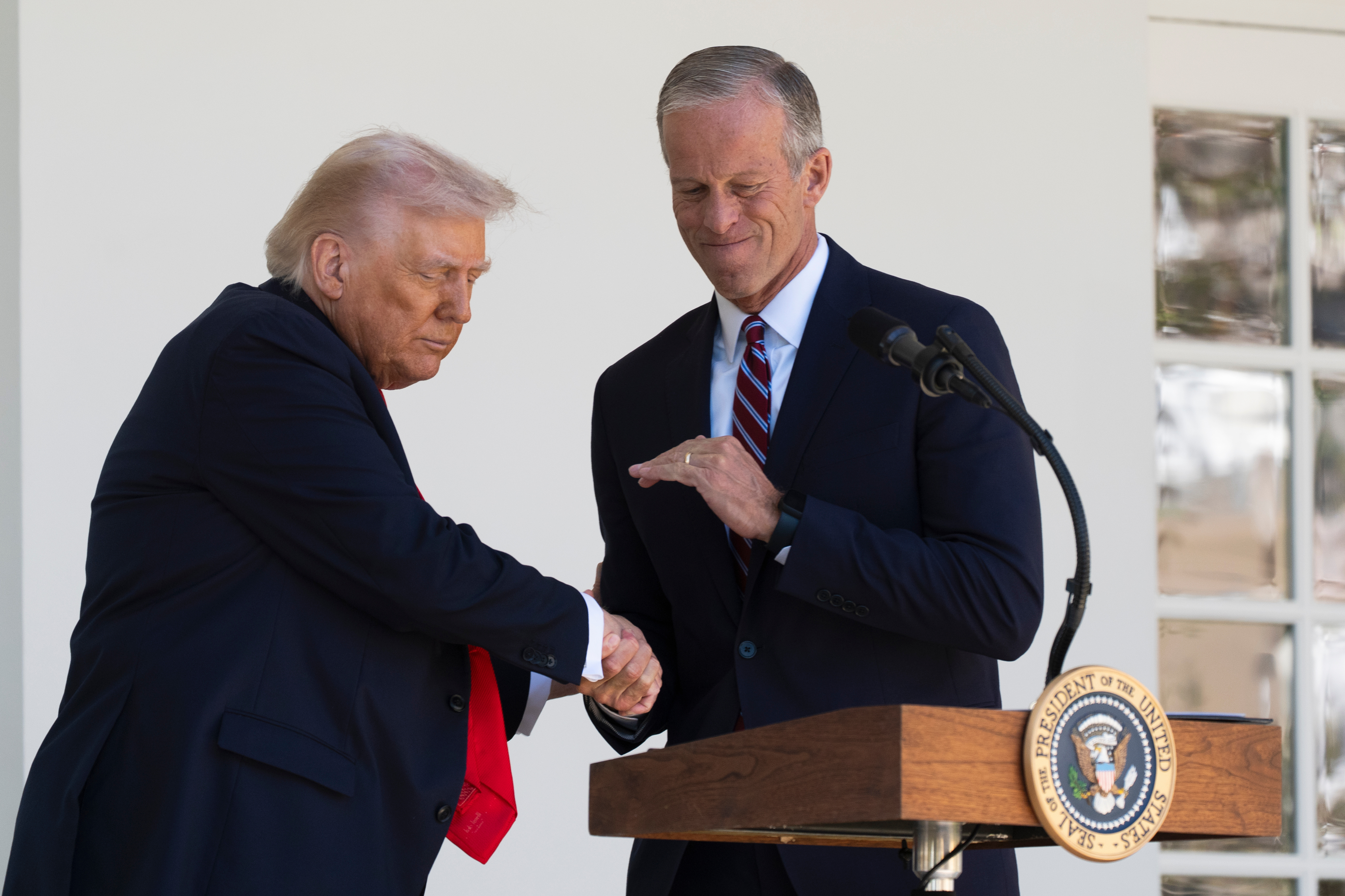 President Donald Trump shakes hands with Senate Majority Leader John Thune, R-S.D., right, during a lunch with Republican Senators on the Rose Garden patio at the White House, Tuesday, Oct. 21, 2025, in Washington.