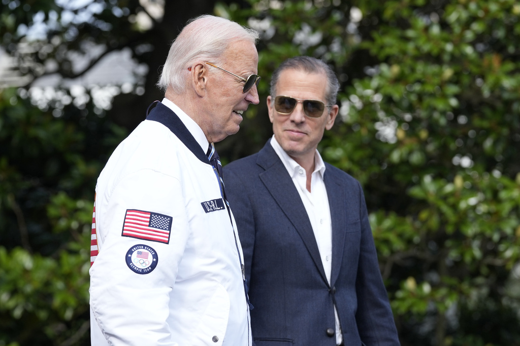 President Joe Biden, wearing a Team USA jacket and walking with his son Hunter Biden, heads toward Marine One on the South Lawn of the White House in Washington, Friday, July 26, 2024. 